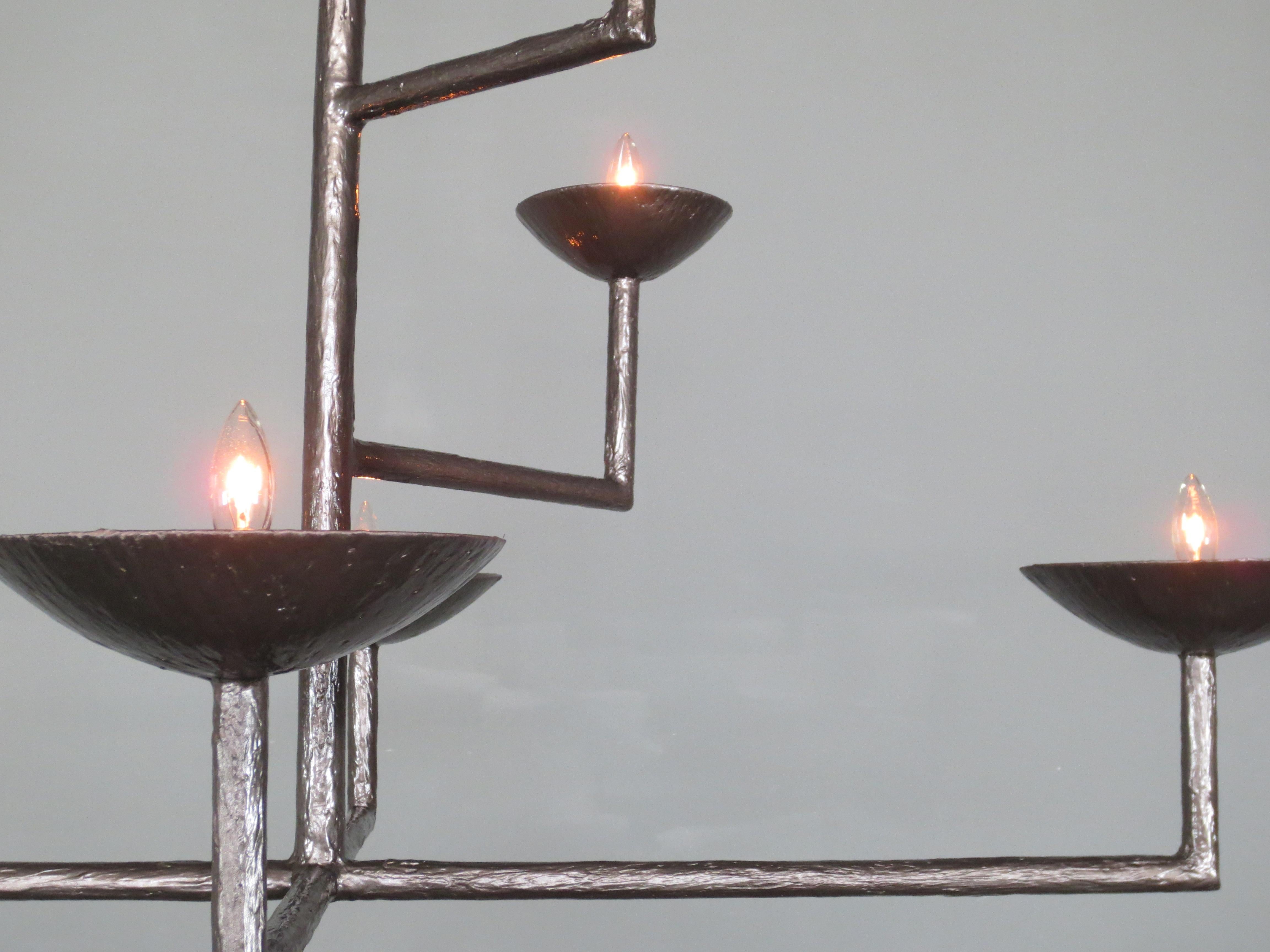 7 Lampadario in gesso con finitura in bronzo e mezza palla e catena di Tracey Garet di Apsara Interior Design
Le 7 Coppe di questo lampadario si trovano su vari livelli. Ogni tazza contiene una luce a candelabro. Il pezzo mostrato è rifinito in