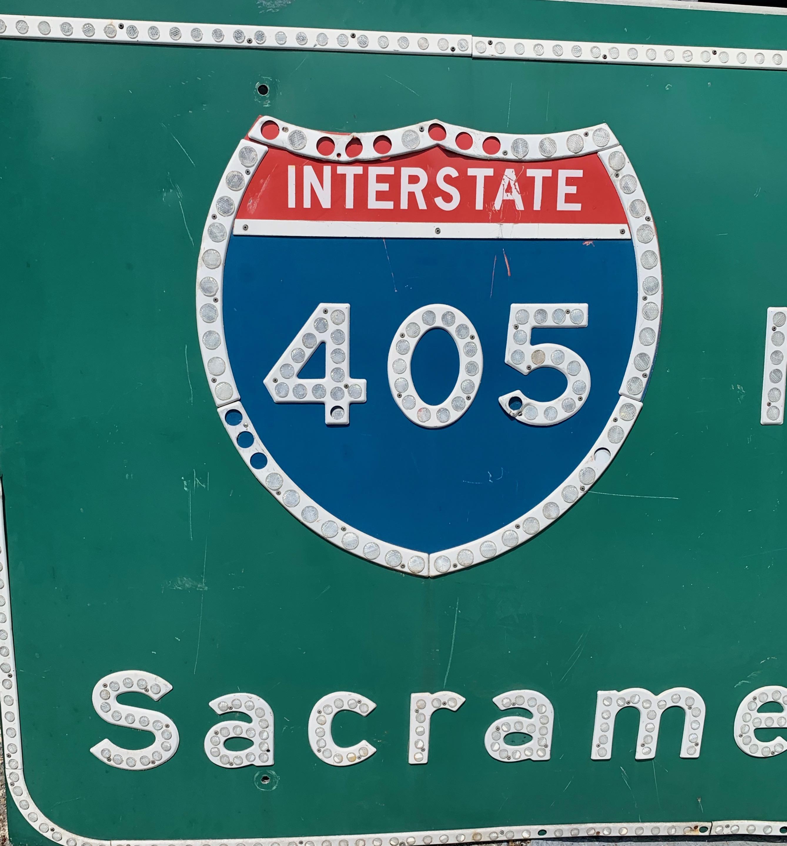 Very cool vintage Los Angeles 405 freeway sign reading NORTH, SACRAMENTO. Lettering made out of reflective pieces, illuminating beautifully. Very cool piece of pop art and LA history. Some missing reflectors and general wear to sign. Great piece of