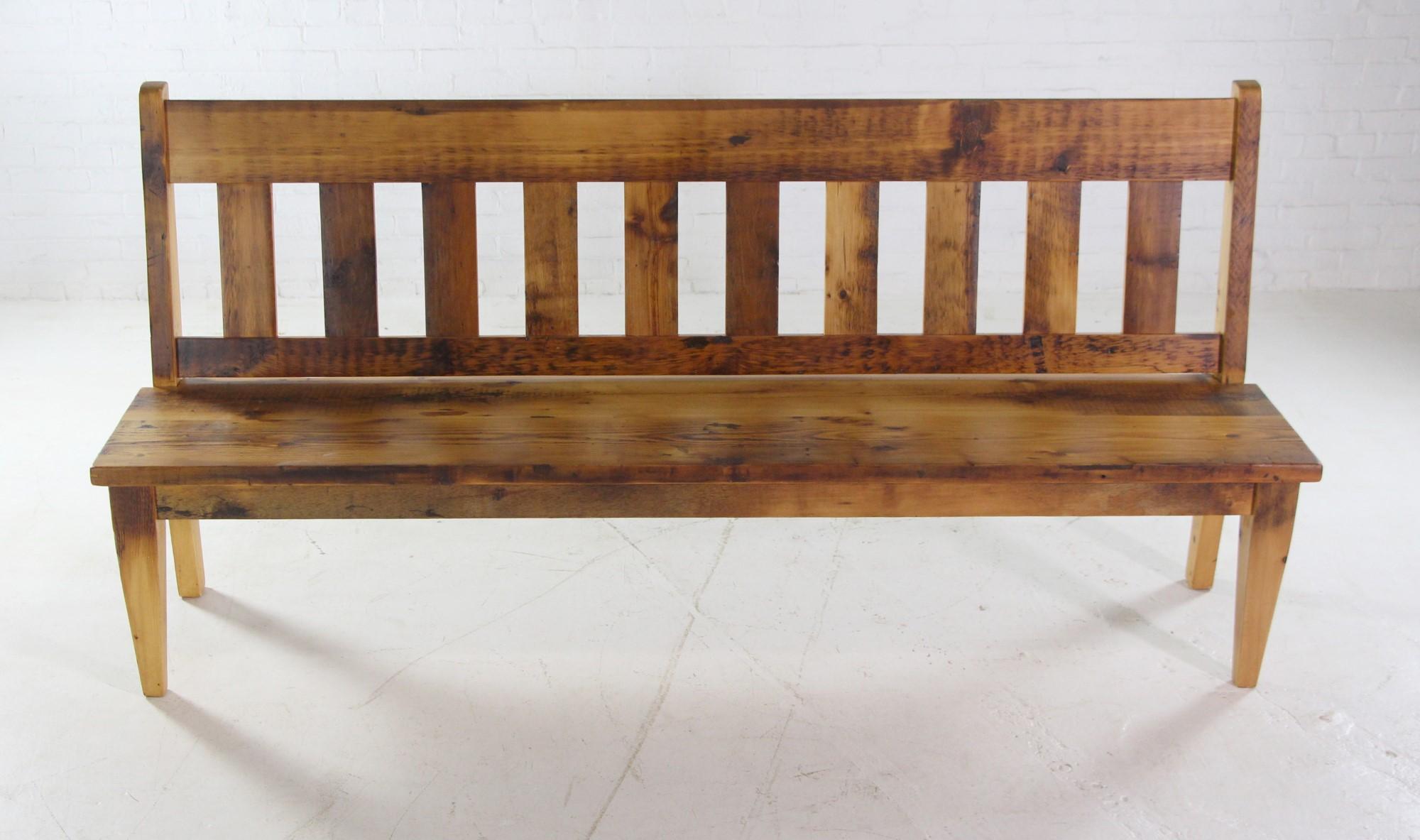7 foot long pine slatted bench with back done in a natural stain finish. It was handcrafted and made from reclaimed pine beams giving it a one-of-a-Kind quality. Small quantity available at time of posting. Please note shading may vary. Small