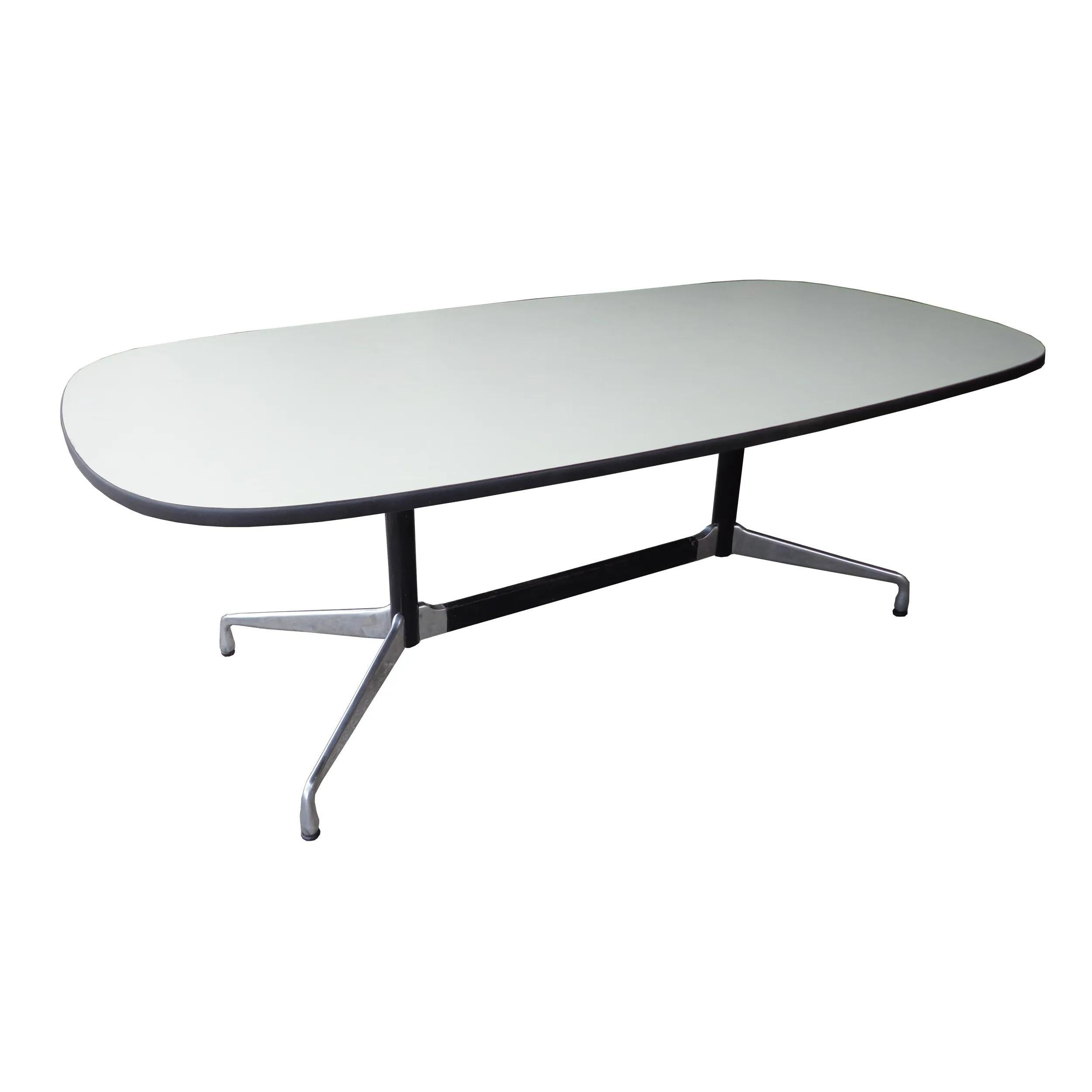 Ray and Charles Eames designed the segmented base dining or conference table with racetrack white laminate top and aluminum base for Herman Miller, 1970s. Clean classic design. Measure: 7 ft.
 