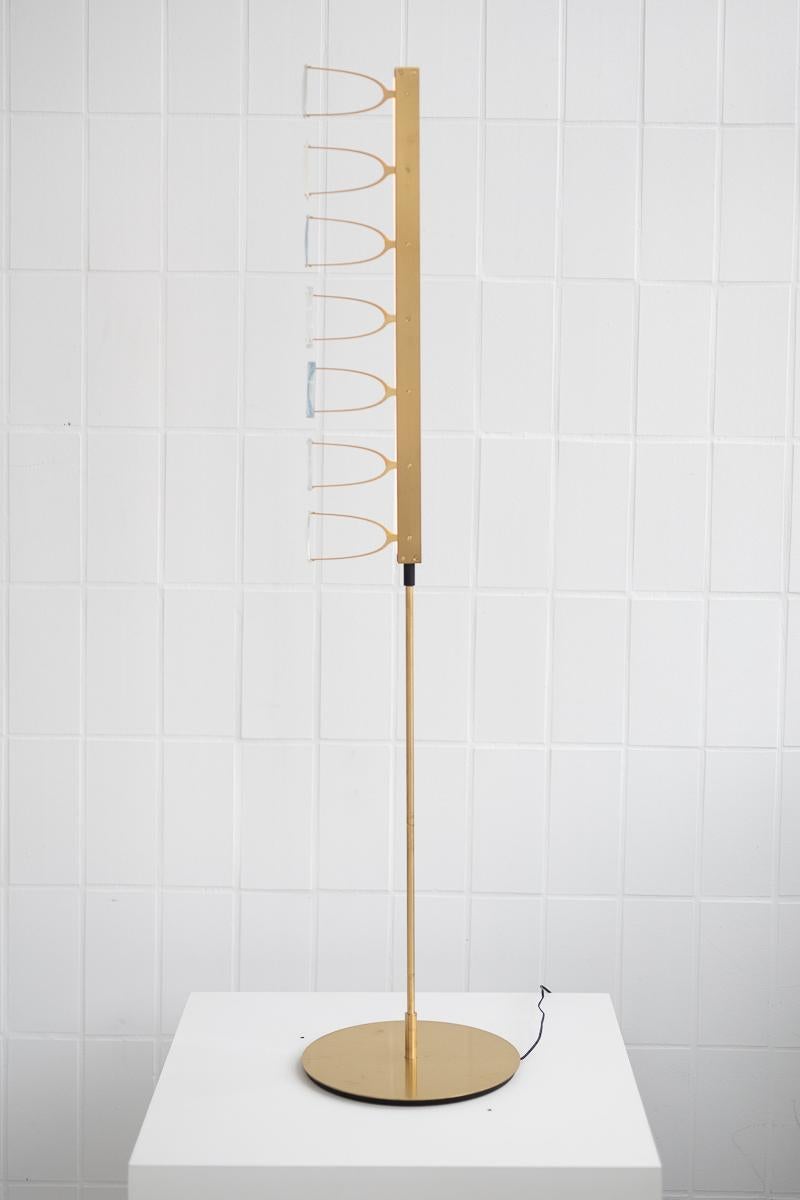 7-Lens floor lamp by Object Density
Handmade
Dimensions: Ø28 x 125 cm
Material: Brass (Messing), Optical lenses, Dimmable 12V LED

Through a close inquiry into an optician’s process and production, Object Density have realised the opportunity