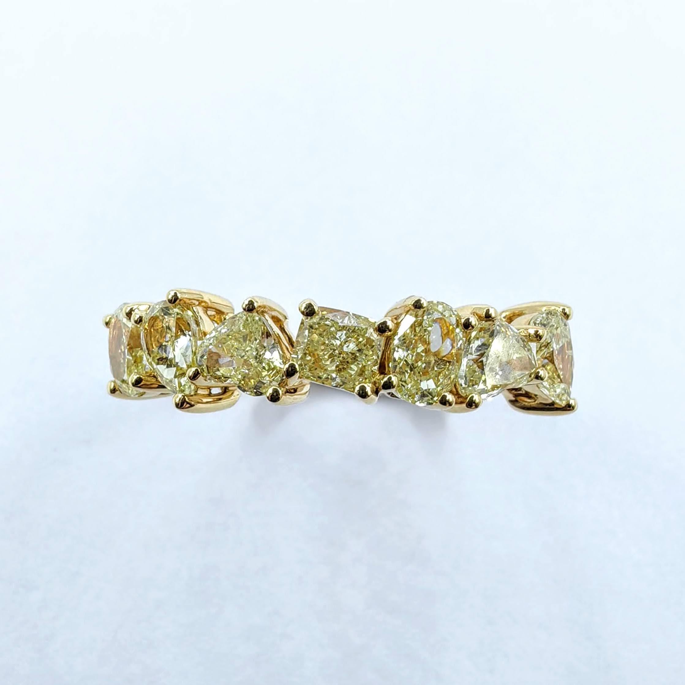 Cette éblouissante bague demi-éternité est une célébration de la couleur, de l'artisanat et de la créativité. Fabriqué à la main dans un luxueux or jaune 18 carats, il présente un arrangement frappant de 7 diamants naturels de couleur jaune