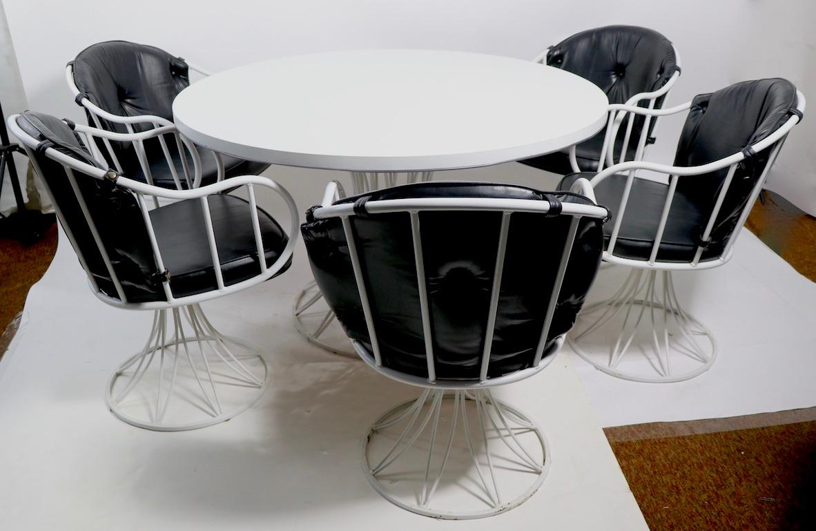 Fabulous and rare Richard McCarthy for Selrite dinette set consisting of 6 swivel armchairs, and 1 circular dining table the chairs have wrought iron frames in white paint finish with original tufted black vinyl backrests and seat cushions. The