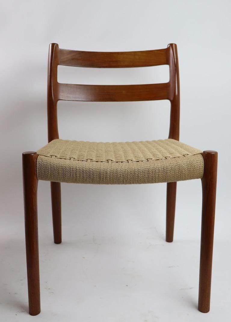 Nice set of 7 solid teak and paper cord dining chairs by J.L. Moller, Hojbjerg Model 84 circa 1960s-10970s. This set consists of 5 armless and 2 armchairs. All chairs are in good, clean ready to use condition.
Dimensions of armchairs: 20.5 depth x