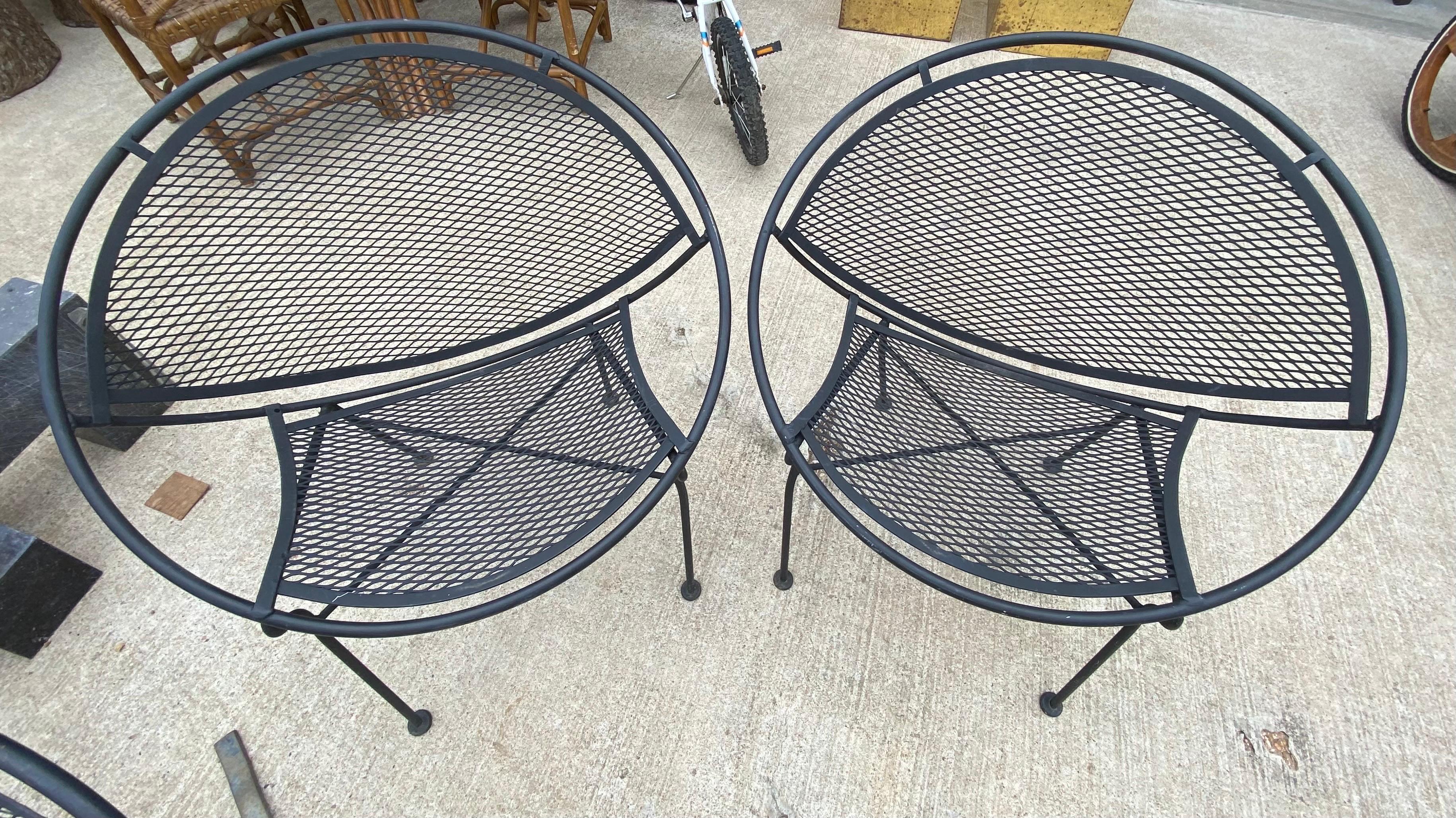 Mid-Century Modern John Salterini 'Radar' outdoor patio set consisting of (2) chairs, (2) rocking chairs, (1) tandem seating, (1) chaise lounge, (1) nesting tables made of metal mesh and wrought iron, totaling to 7 pieces. Age-appropriate wear on