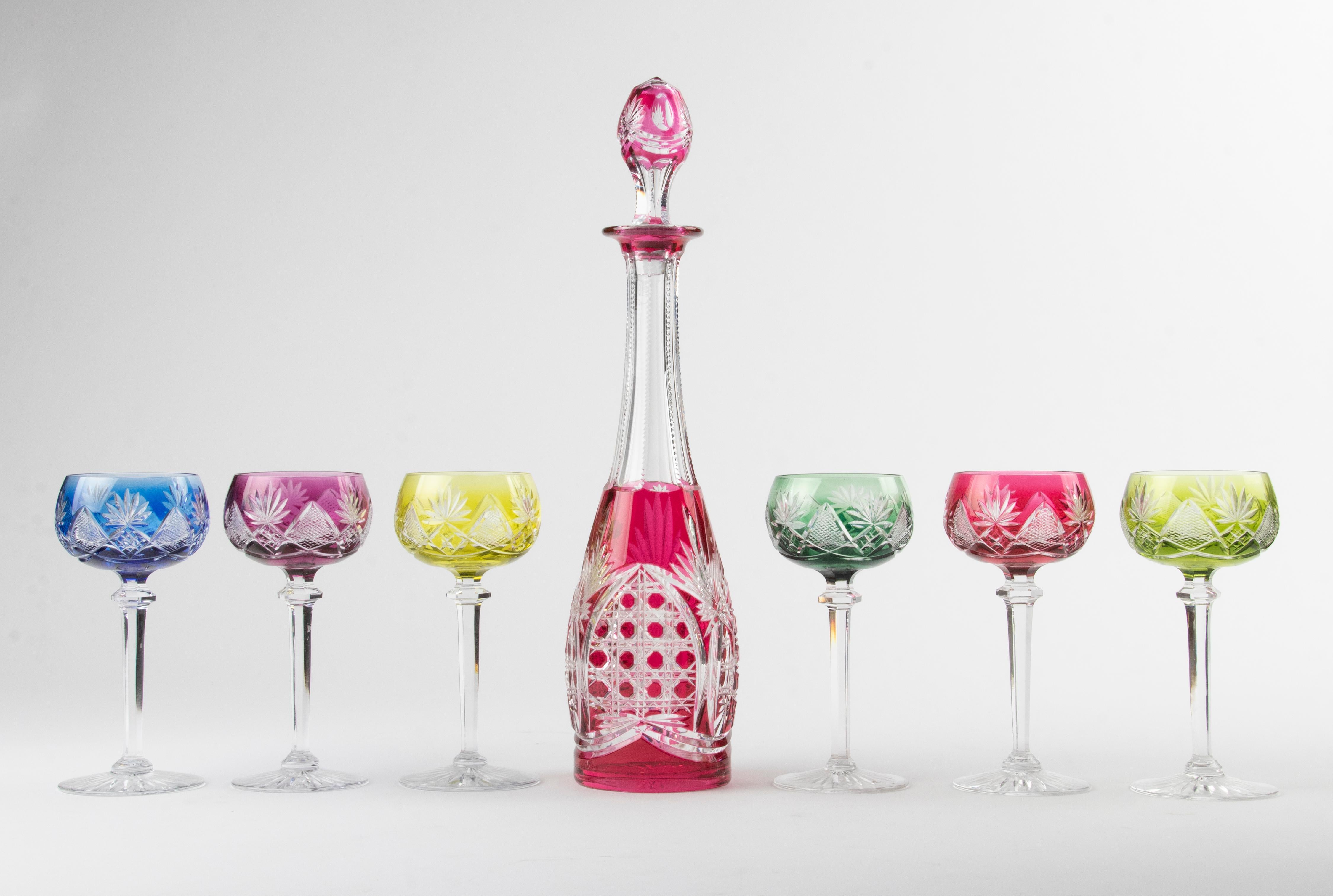 Beautiful set of colored crystal wine glasses with matching decanter from the Belgian brand Val Saint Lambert. The glasses have beautiful sharpening and beautiful deep colours. Both the glasses and the decanter are signed on the bottom. The set is