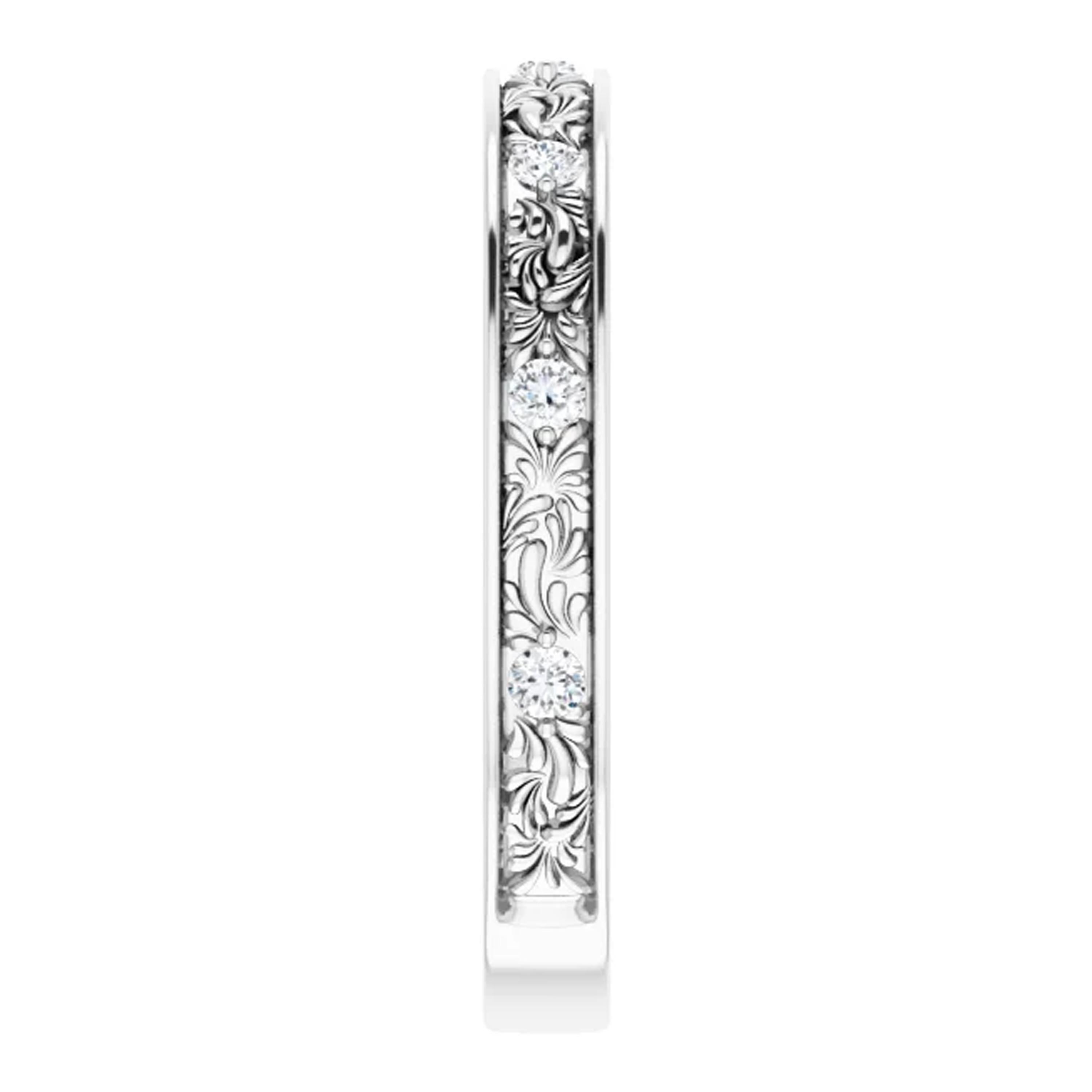 Shimmering white diamonds adorn the shank of this dainty wedding ring. Handcrafted meticulously in 18k white gold, intricate filigrees decorate the band. Finished with a high polish and rhodium plated for additional brilliance, this vintage style