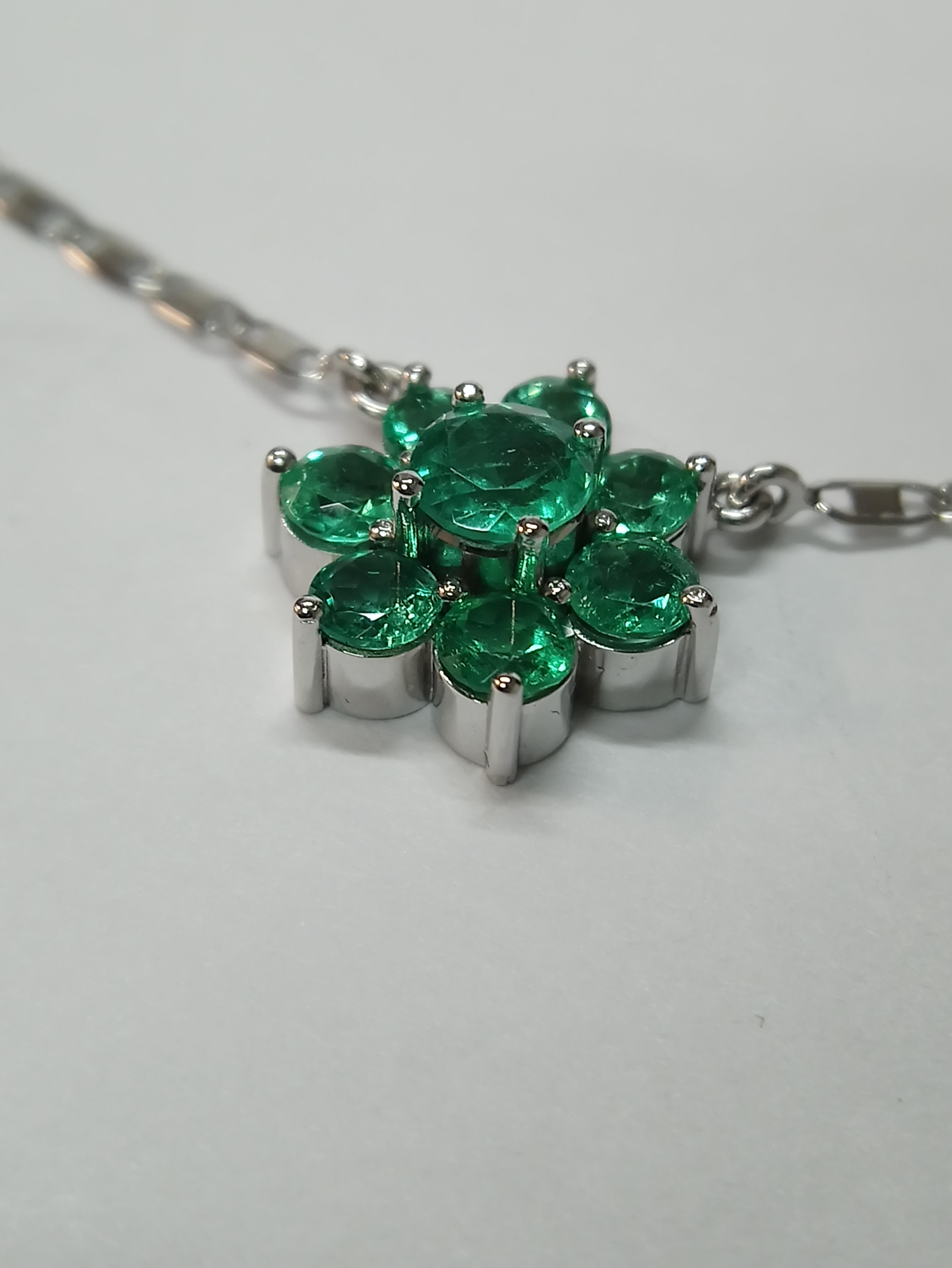 Set in 18K white gold, this cluster necklace contains six, 1 carat, round cut Colombian emeralds surrounding a 2 carat Colombian emerald centre stone. This piece includes a re-sizeable chain necklace.