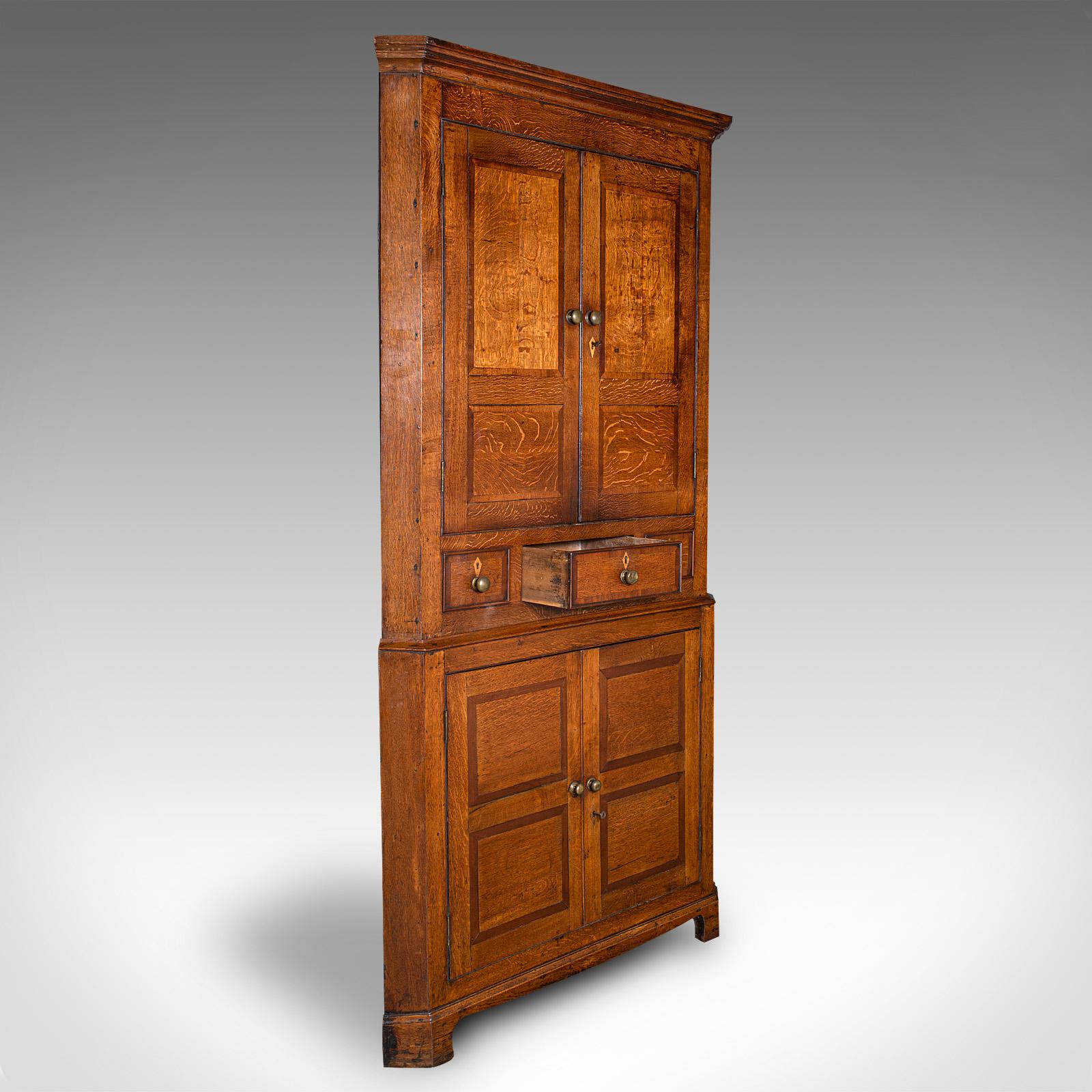 This is a 7' tall antique country manor corner cabinet. A Scottish, fine oak two-tier cupboard, dating to the Georgian period, circa 1750.

Superb Baronial cabinet, with striking proportion and vibrant painted interior
Displays a desirable aged