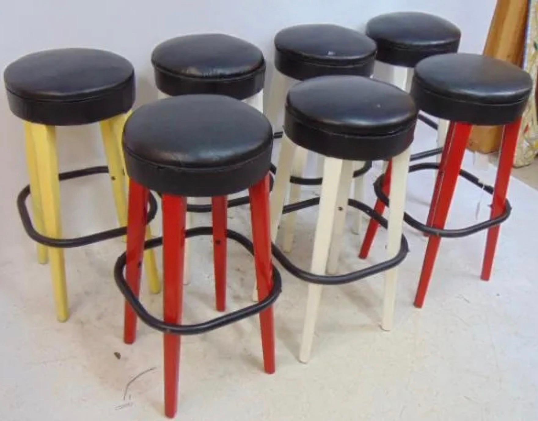An authentic collection of 3 of 7 still remaining iconic Thonet stools from the 1930s, marked on the underside with Thonet Logo and certificate.  2 red, 1 yellow painted wooden base with chrome foot support and black vinyl seats. Paint is not