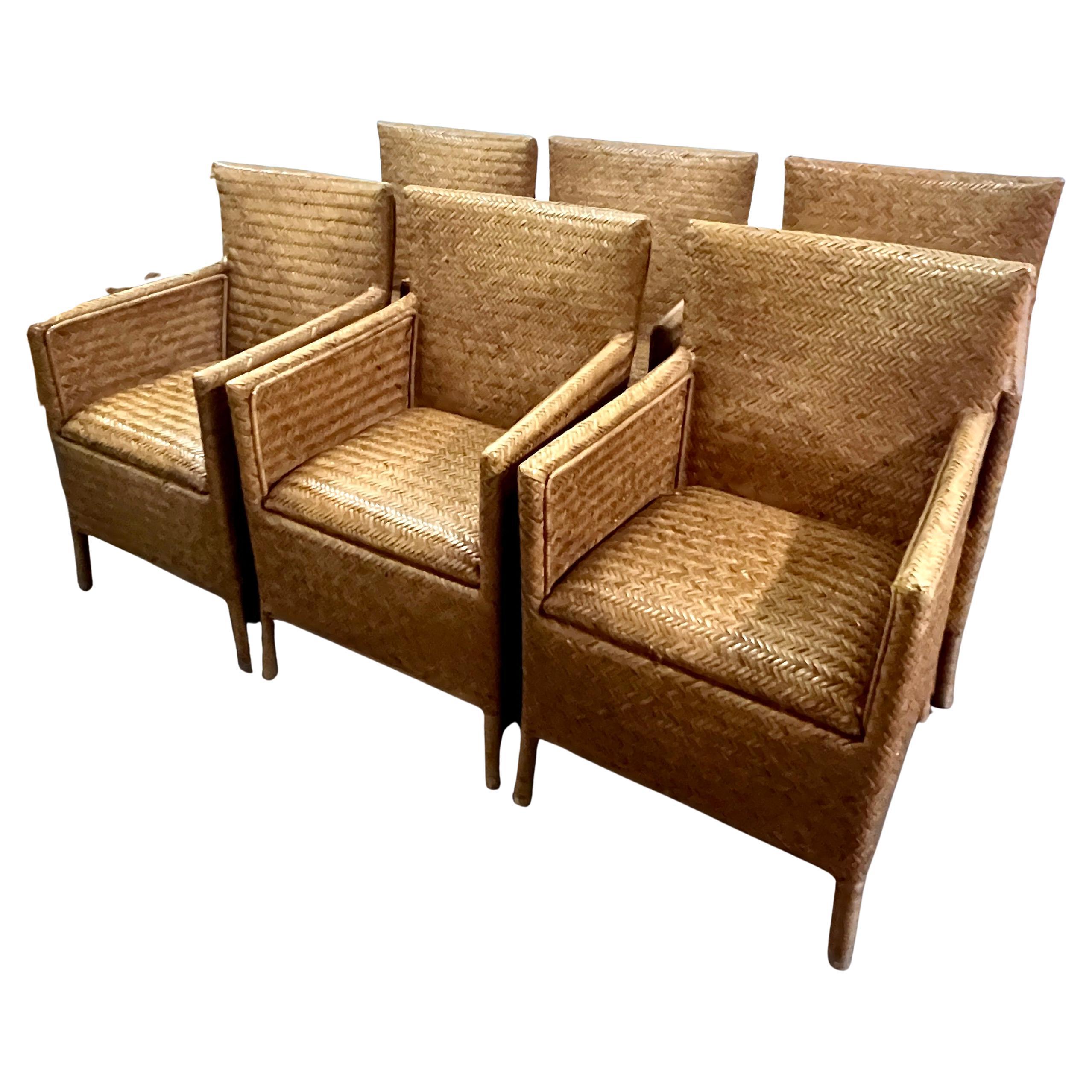 7 Chaises en rotin tressé avec accoudoirs, pour la salle à manger.  Les chaises sont tissées de manière complexe avec des détails de bandes à l'intérieur et à l'extérieur du dos - très sexy et aérodynamique dans le style de Ralph Lauren.

Sept