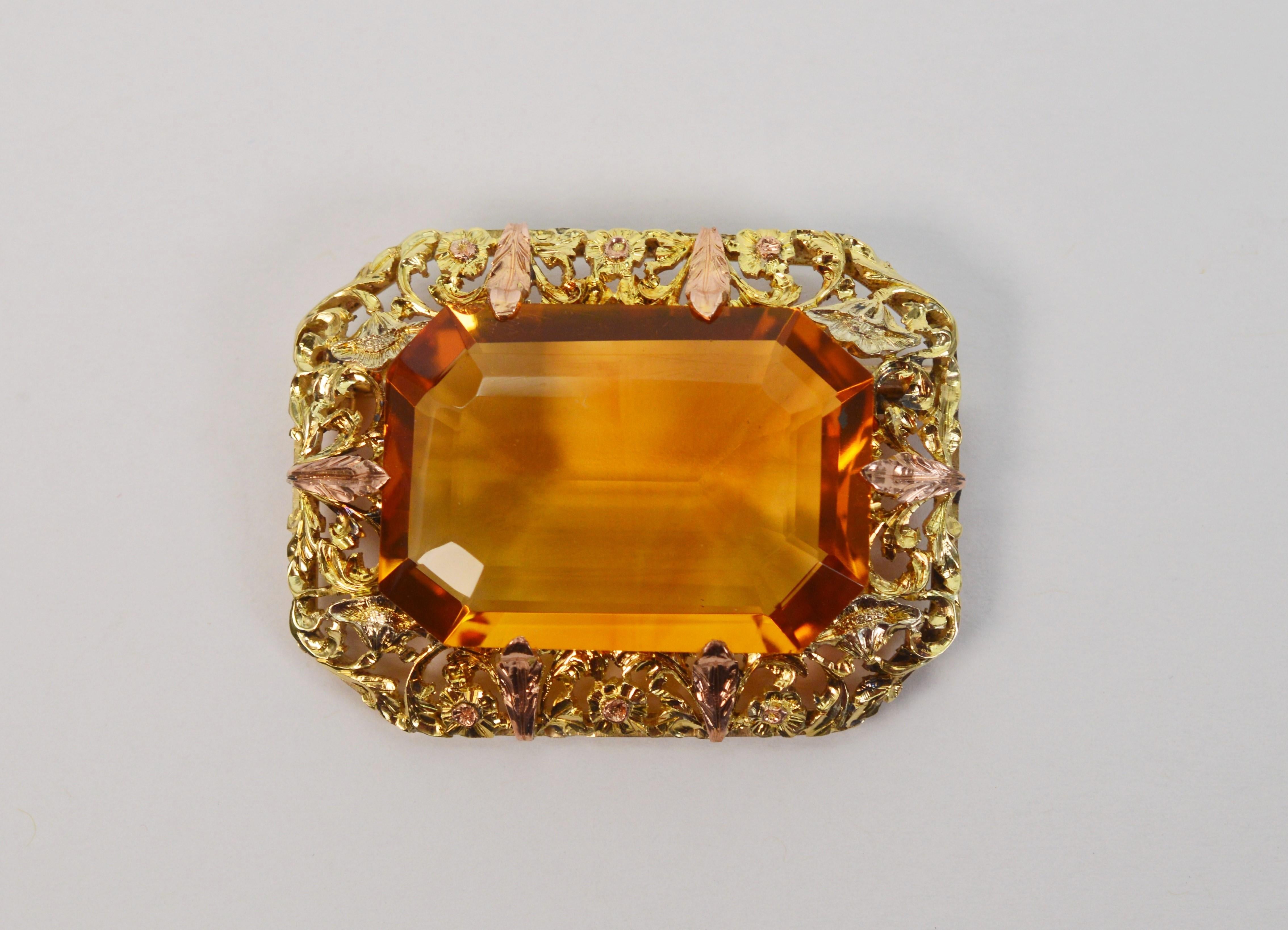 Outstanding circa 1940 finery, a remarkable seventy carat emerald cut natural orange brown citrine is artfully displayed in hand tooled gold filigree made of twelve karat 12k yellow gold and adorned with rose gold accents. The AAA stone is eye clean