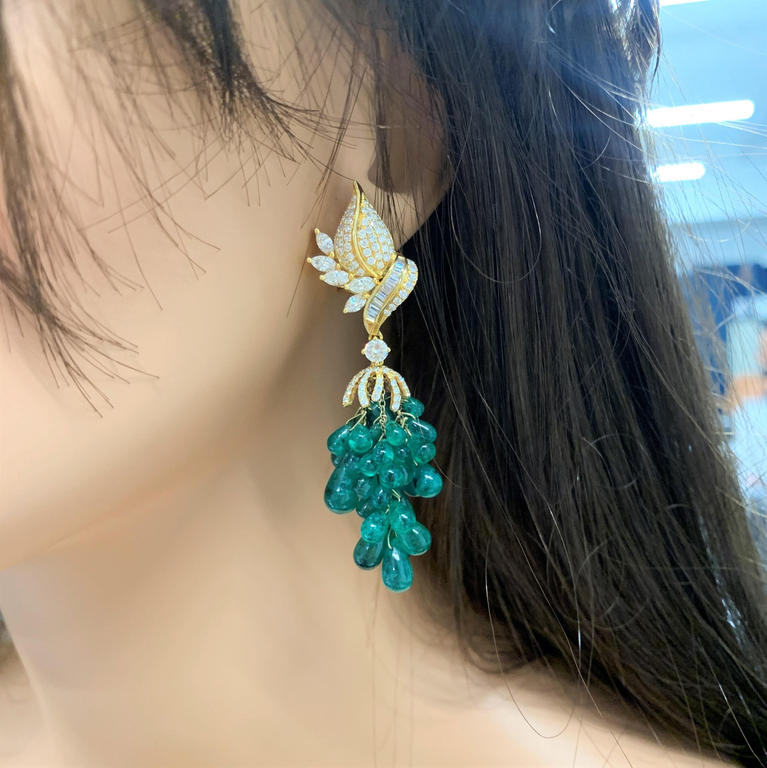 These hand-designed brightly polished 18k yellow gold nature-inspired garden dangle earrings drip with a decadent amount of fine quality emerald briolette beads that are set on the bottom in bunches totaling 70.00 carats. These incredible Colombian