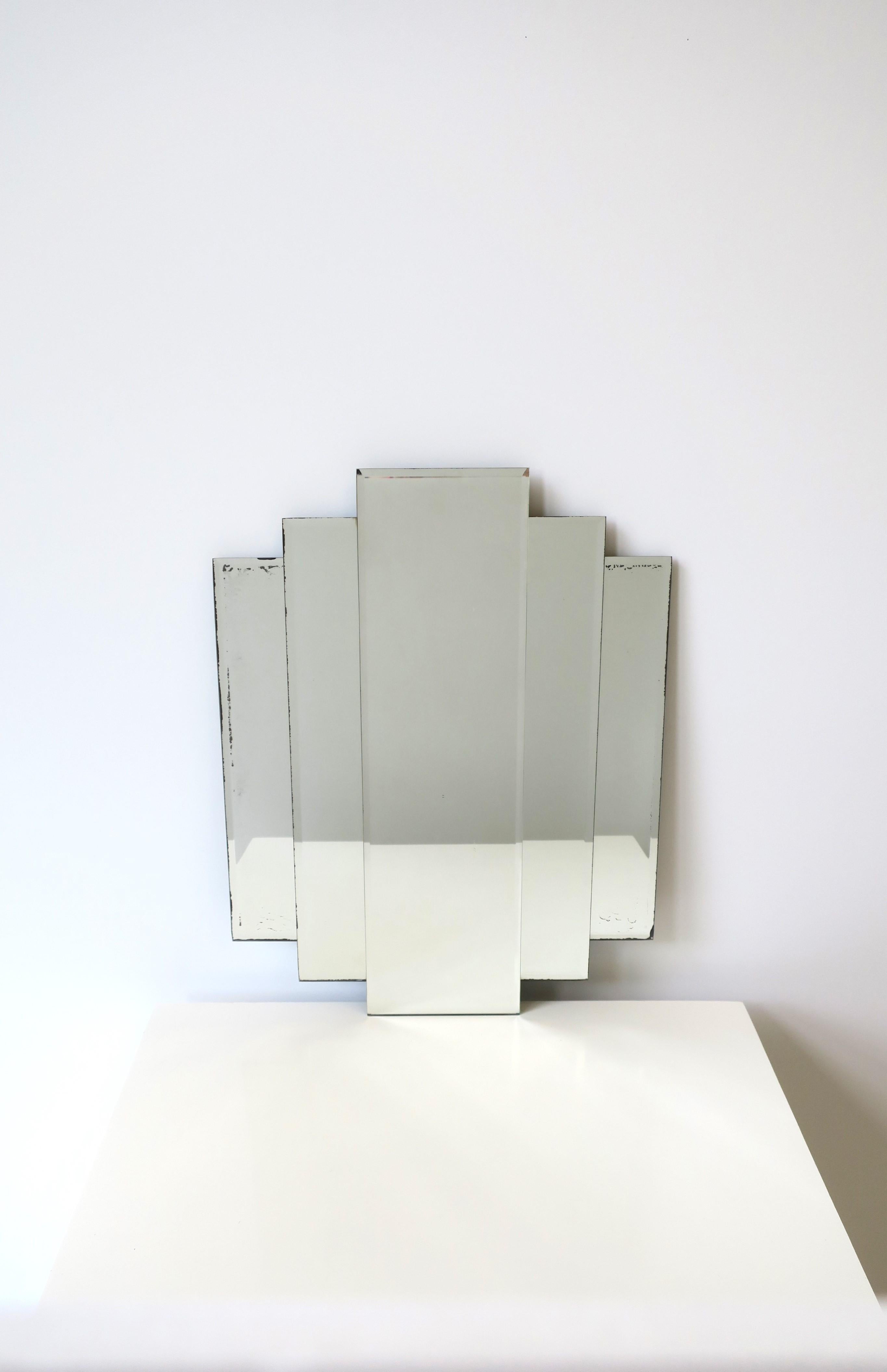 A beautiful '70 Modern Art Deco wall or vanity mirror, circa 1970s, New York. Mirror is comprised of three pieces of mirror, each with a beveled edge. A chic mirror for any wall including in a bathroom, vanity area, walk-in-closet, etc. Piece is