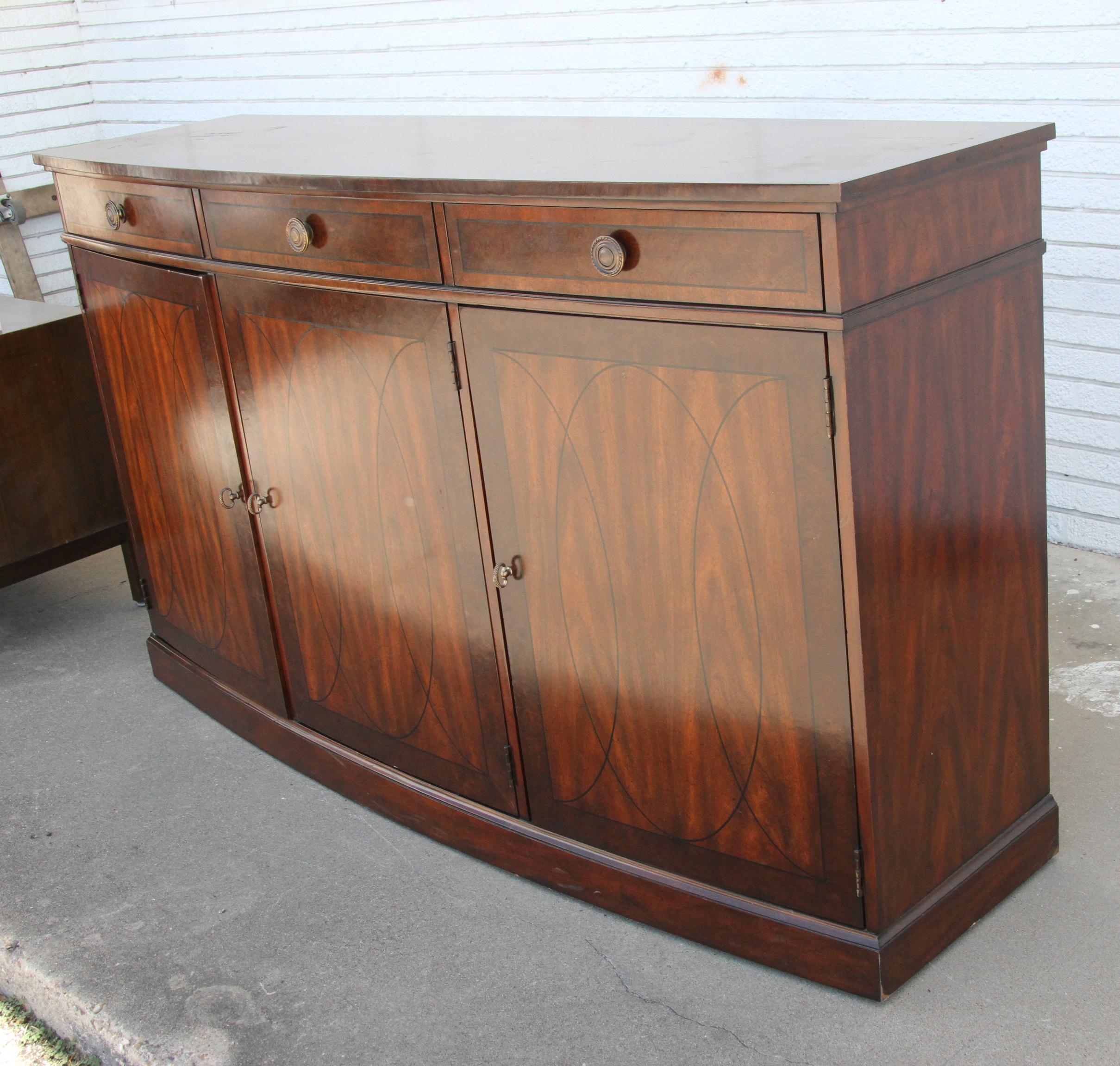 Georgian Style Sideboard  by Robb & Stucky, Circa 1980s 

3 door with shelving and book-matched mahogany, decorative inlay and original brass hardware.

Measures: 70”W x19