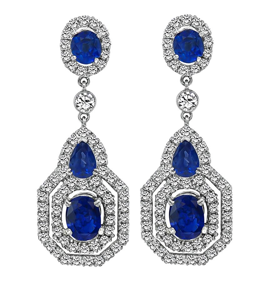 This is a gorgeous pair of 18k white gold dangling earrings. The earrings feature lovely pear and oval cut sapphires that weigh approximately 7.00ct. The sapphires are accentuated by sparkling round cut diamonds that weigh approximately 3.00ct. The