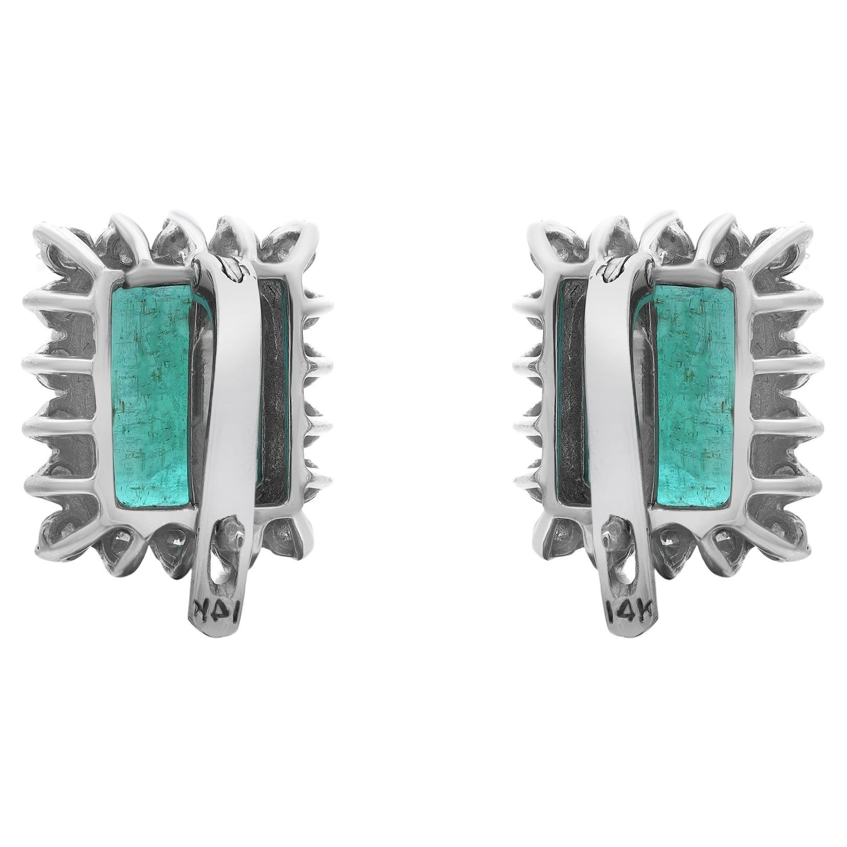Delight the one you adore with these charming Green Emerald stud earrings. Crafted in high polished 14K white gold. The earrings feature prong set emerald cut emeralds weighing 7.00 carats with shimmering round brilliant cut diamonds weighing 1.08