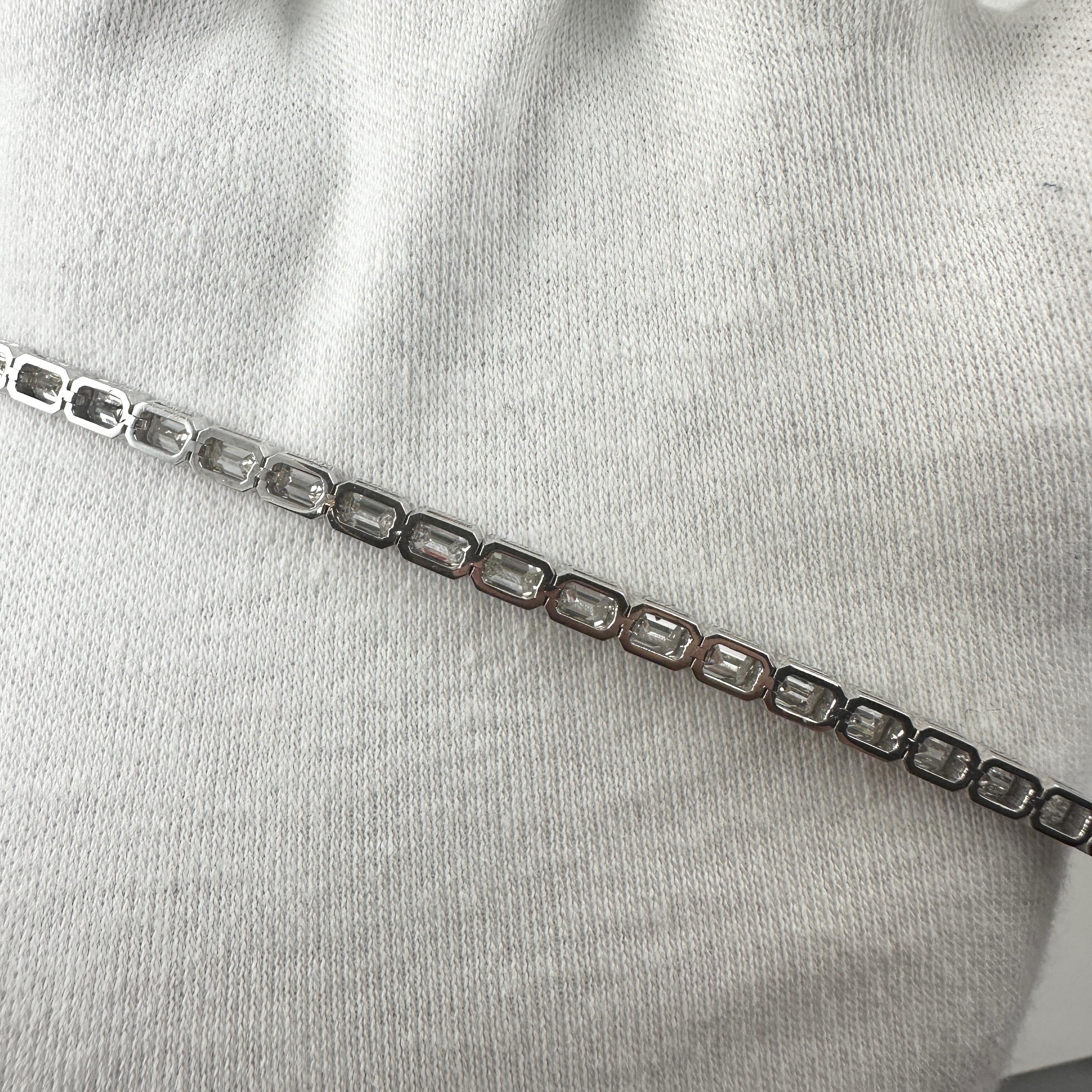Una straordinaria interpretazione moderna del classico bracciale tennis, questo bracciale con diamanti taglio smeraldo presenta un elegante design est-ovest che enfatizza la geometria pulita e l'eleganza senza tempo dei diamanti taglio a gradino.