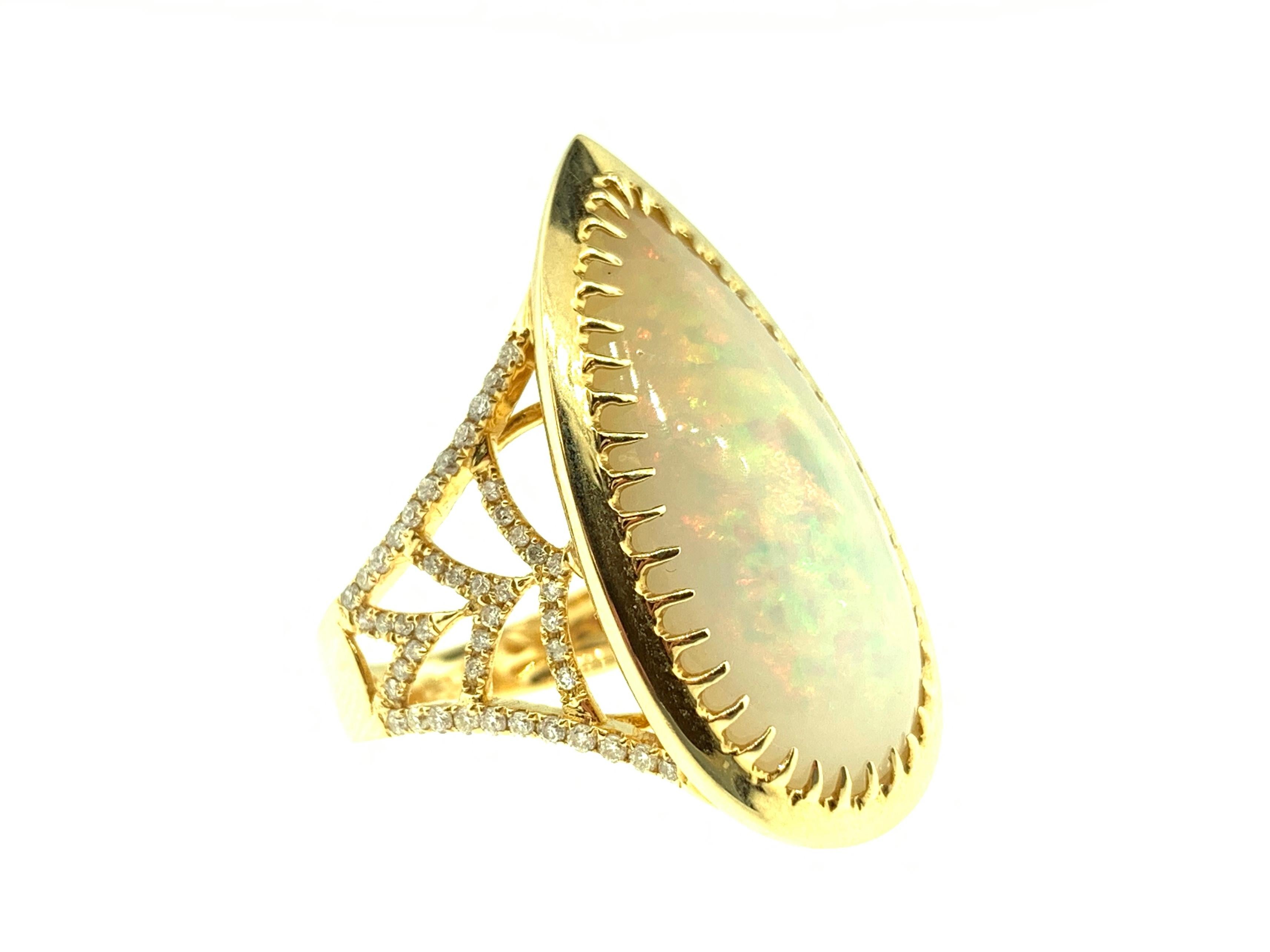 This stunning ring features a 7.01 Carat Ethiopian Pear Opal on a Diamond encrusted shank. This ring is set in 18k Yellow Gold. 
Total Diamond Weight = 0.38 Carats. Ring Size is 6 1/2.