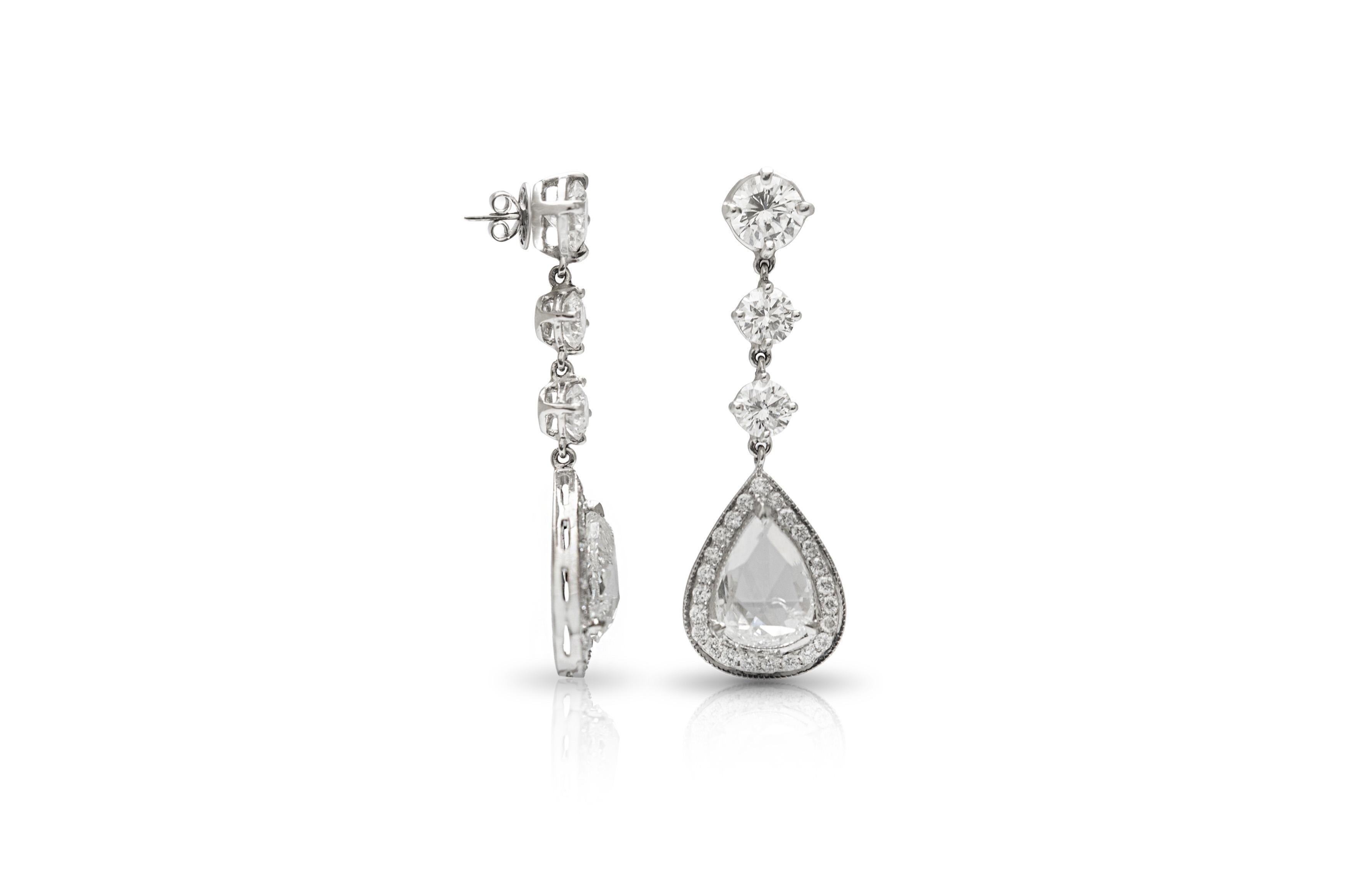 Finement travaillée en or blanc 18k avec 2 diamants de forme poire taillés en rose pesant un total de 3,73 carats, tous deux de couleur G, pureté SI1.
Les boucles d'oreilles sont ornées de deux diamants ronds de taille brillant pesant 1,28 carat et