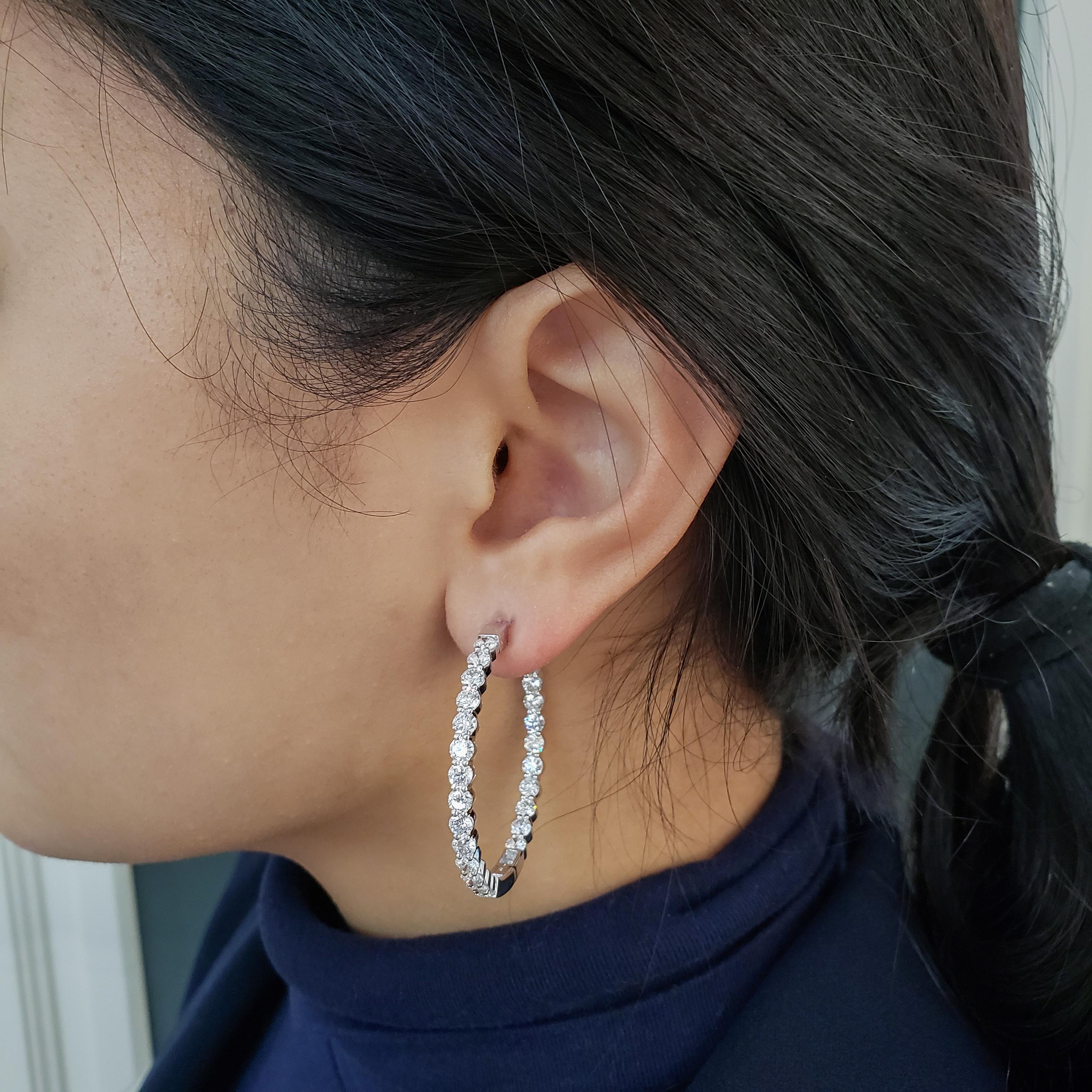 This gorgeous hoop earrings showcasing diamonds set in the inside of the ear and on the outside, in a single shared prong setting. Diamonds weigh 7.11 carats total. Made in 18K White Gold, 1.5 inches in Length. 
Roman Malakov is a custom house,