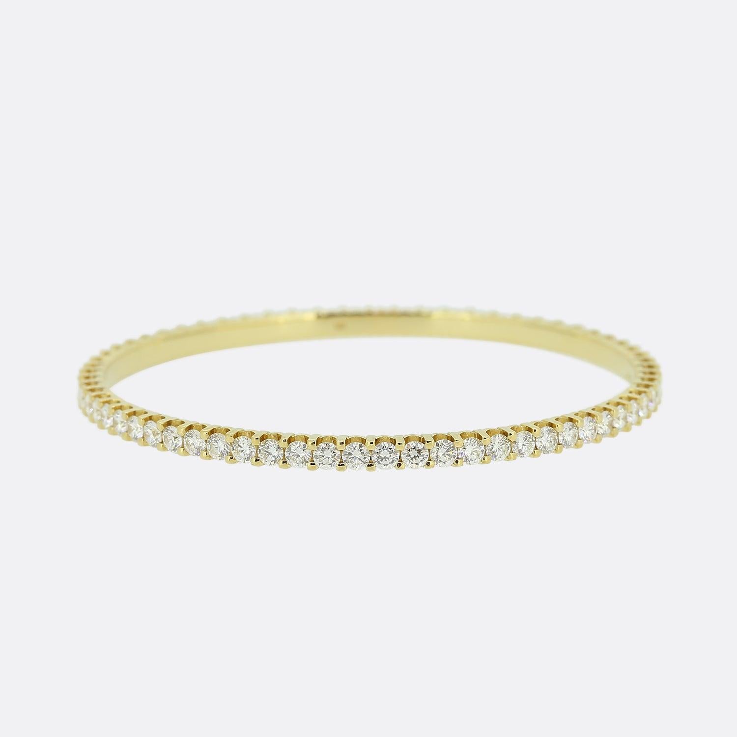 This is an 18ct yellow gold diamond bangle. The circular bangle plays host to 66 round brilliant cut diamonds collectively totalling 7.20 carats; all of which are perfectly matched for colour and clarity and have been individually claw-set around