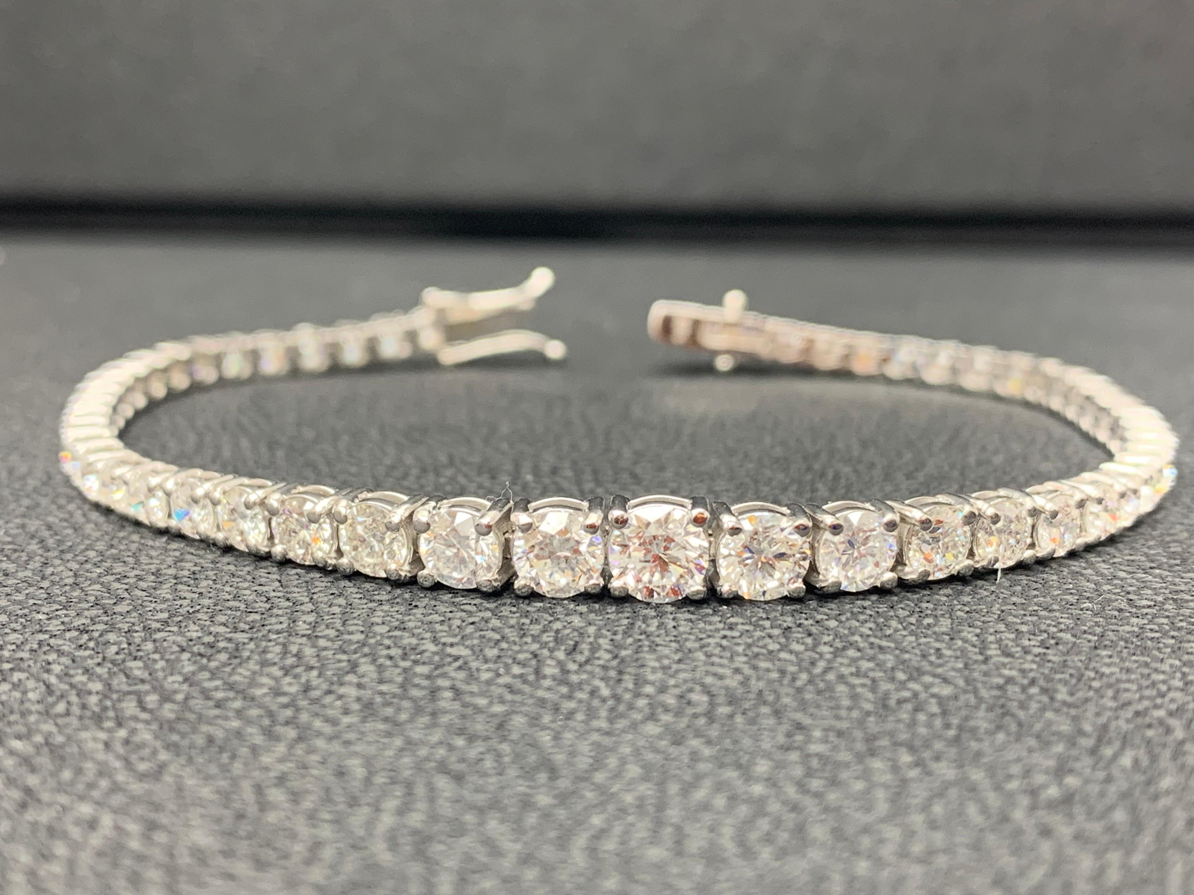 An important piece of jewelry showcasing a row of round brilliant diamonds in a four-prong open gallery setting made in 14k White Gold. Diamonds weigh 7.02 carats total. Each stone graduates larger in size as it reaches the middle of the