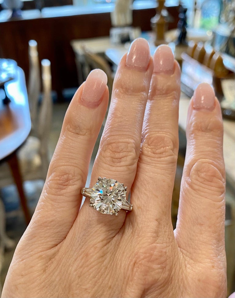 Round brilliant diamond engagement ring with store tapered baguettes
