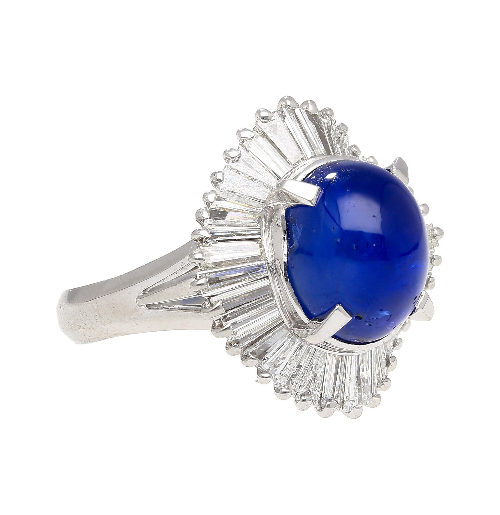 This magnificent ring is crafted from platinum 900 featuring a cathedral style band and gorgeous filigree. Displayed as the center stone is a dazzling cabochon cut star sapphire weighing 7.04 carats, measuring 10.1x8.5mm, captivating with its deep