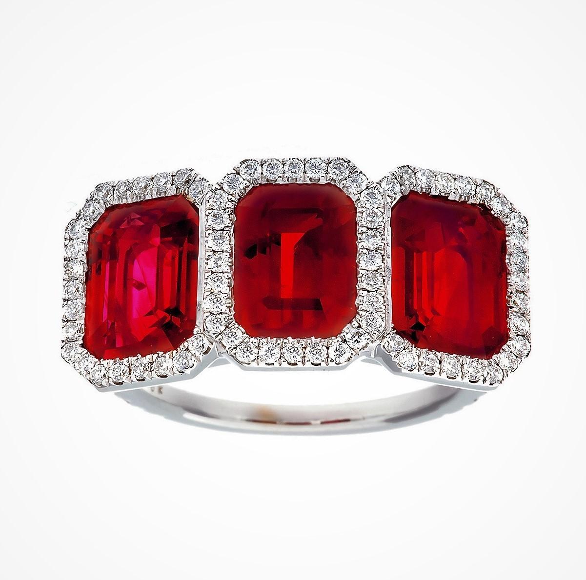 18 Karat White Gold Emerald Cut  3-Stone Burma Ruby And Diamond Ring, 
Set With 3-Matching Rubies To Total 7.05 Carats, 
With Very Fine Pigion Blood Red Color, 
The Ring Is Further Set Around With 92 Small Brilliant Cut Diamonds To Total 0.67 Carats