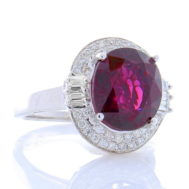 This striking piece features a flattering, fully faceted 7.05 carat -11.61 X 10.13 millimeter spessartite garnet that exhibits a vivid red hue. The gem source is Madagascar; its transparency and luster are superb. The gem is accompanied with a fancy