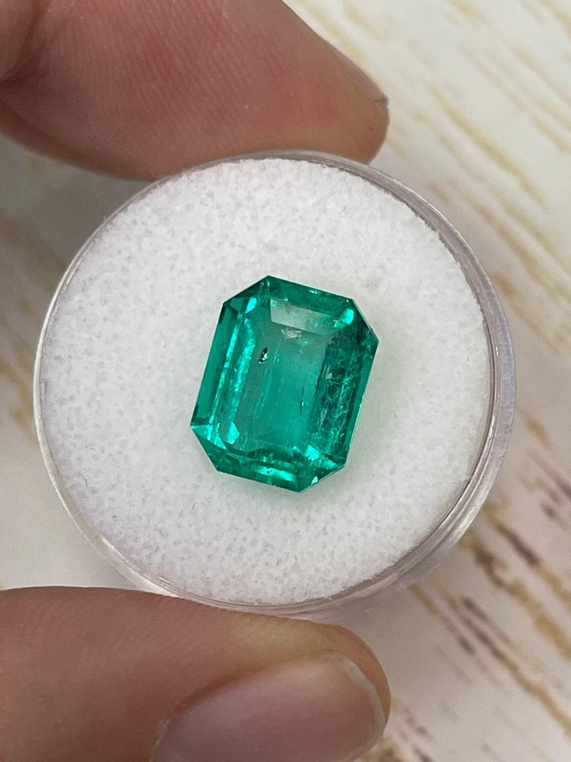Modern 7.06 Carat 12x9.5 Glowing Bluish Green Colombian Emerald - Emerald Cut Muzo Mine For Sale