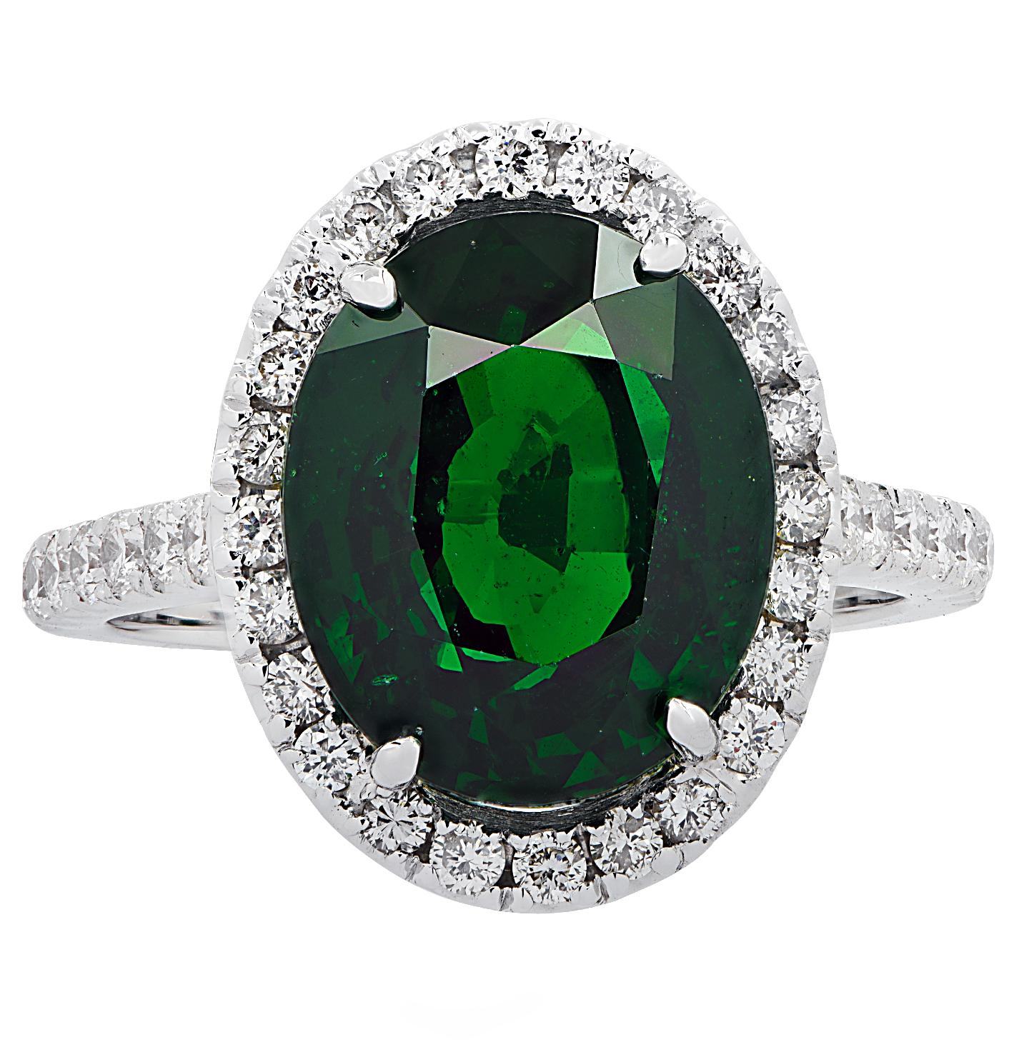 Gorgeous ring crafted in 18 karat white gold, showcasing a beautiful green oval Tsavorite weighing 7.07 carats, adorned with 38 round brilliant cut diamonds weighing approximately .60 carats, G color, VS clarity. The Tsavorite takes center stage in