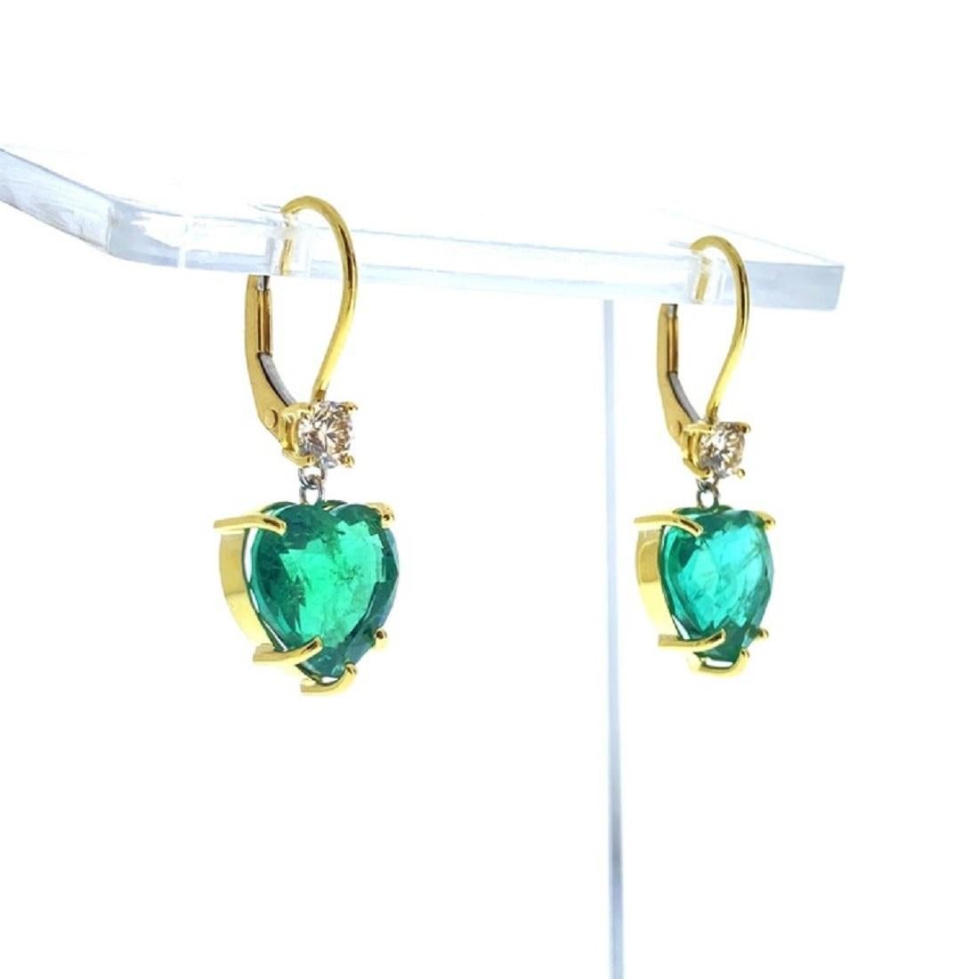 The 7.08 carat Heart Shape Green Emerald Earrings in 18K Yellow Gold are a dazzling and romantic pair of earrings that combine classic elegance with a burst of vivid color. These earrings feature two breathtaking heart-shaped emerald gemstones,