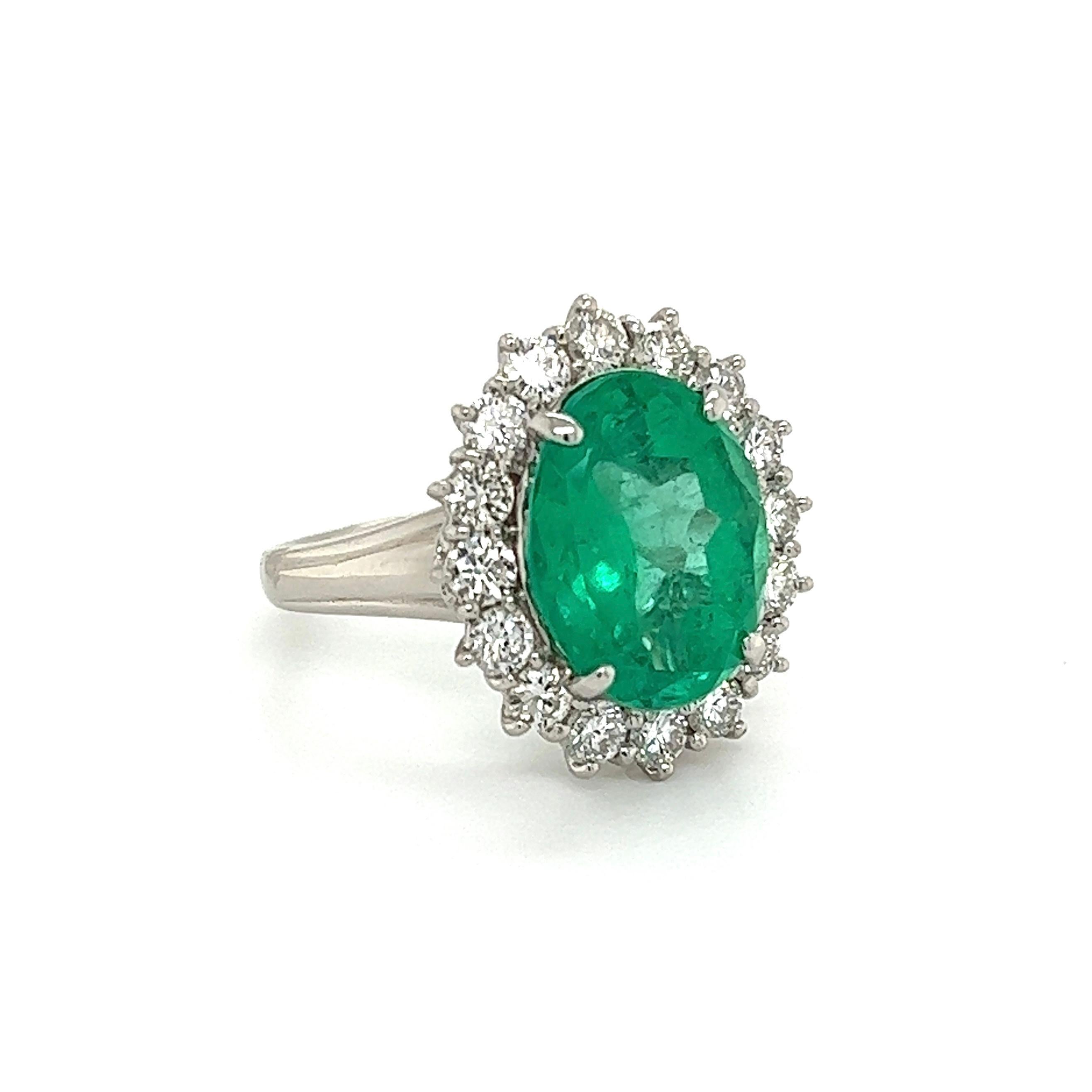 Simply Beautiful! Finely detailed Emerald and Diamond Platinum Ring. Centering a securely nestled Hand set 7.09 Carat Oval Columbian Emerald GIA #5222270569, surrounded by Diamonds, weighing approx. 1.38tcw. Hand crafted Platinum mounting. Approx.