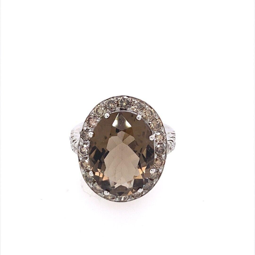 This beautiful ring is made in Italy from 18ct white gold. The center stone is a 7.0ct oval smokey quartz. Surrounding this are 30 champagne colour natural diamonds. A unique addition to your jewellery collection.

Additional Information: 
Total