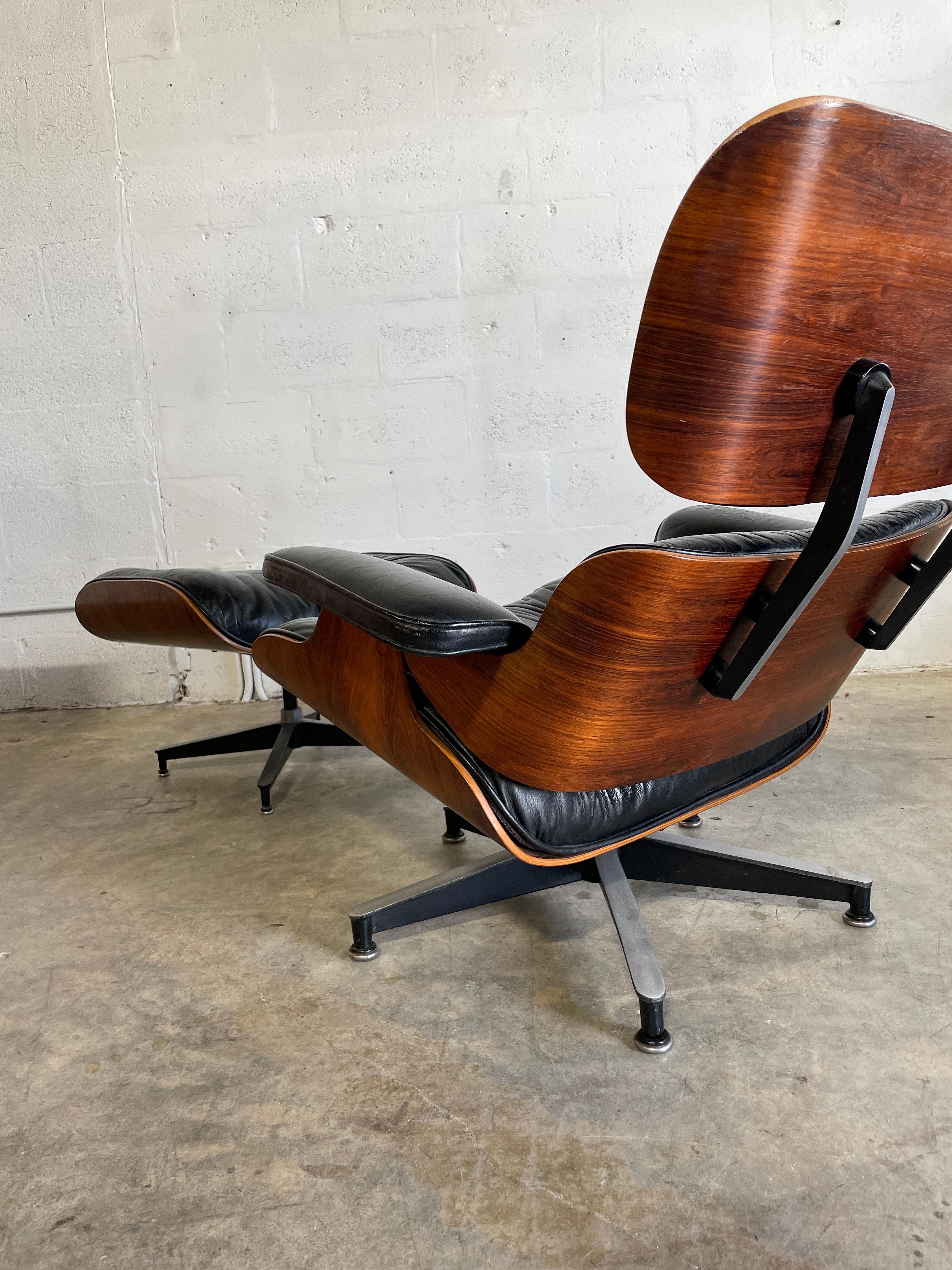 70s 80s Authentic Eames for Herman Miller Lounge Chair and Ottoman. Rosewood veneer case and black leather cushions. Labeled. Wear commensurate with age. 