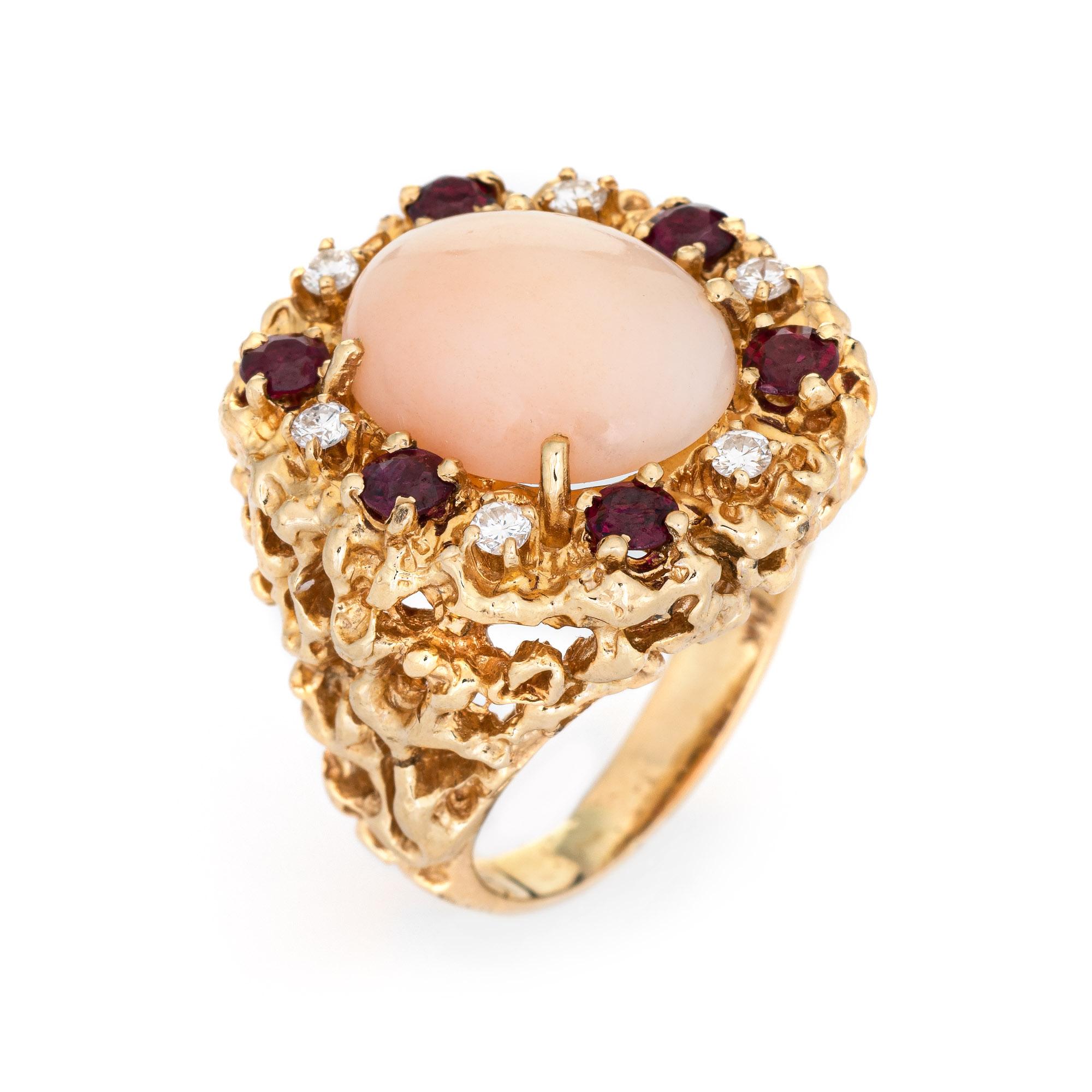 Stylish vintage angel skin coral, ruby & diamond ring (circa 1970s) crafted in 14 karat yellow gold. 

Cabochon cut angel skin coral measures 15mm x 12mm (estimated at 8.50 carats). The coral is in very good condition and free of cracks or chips.