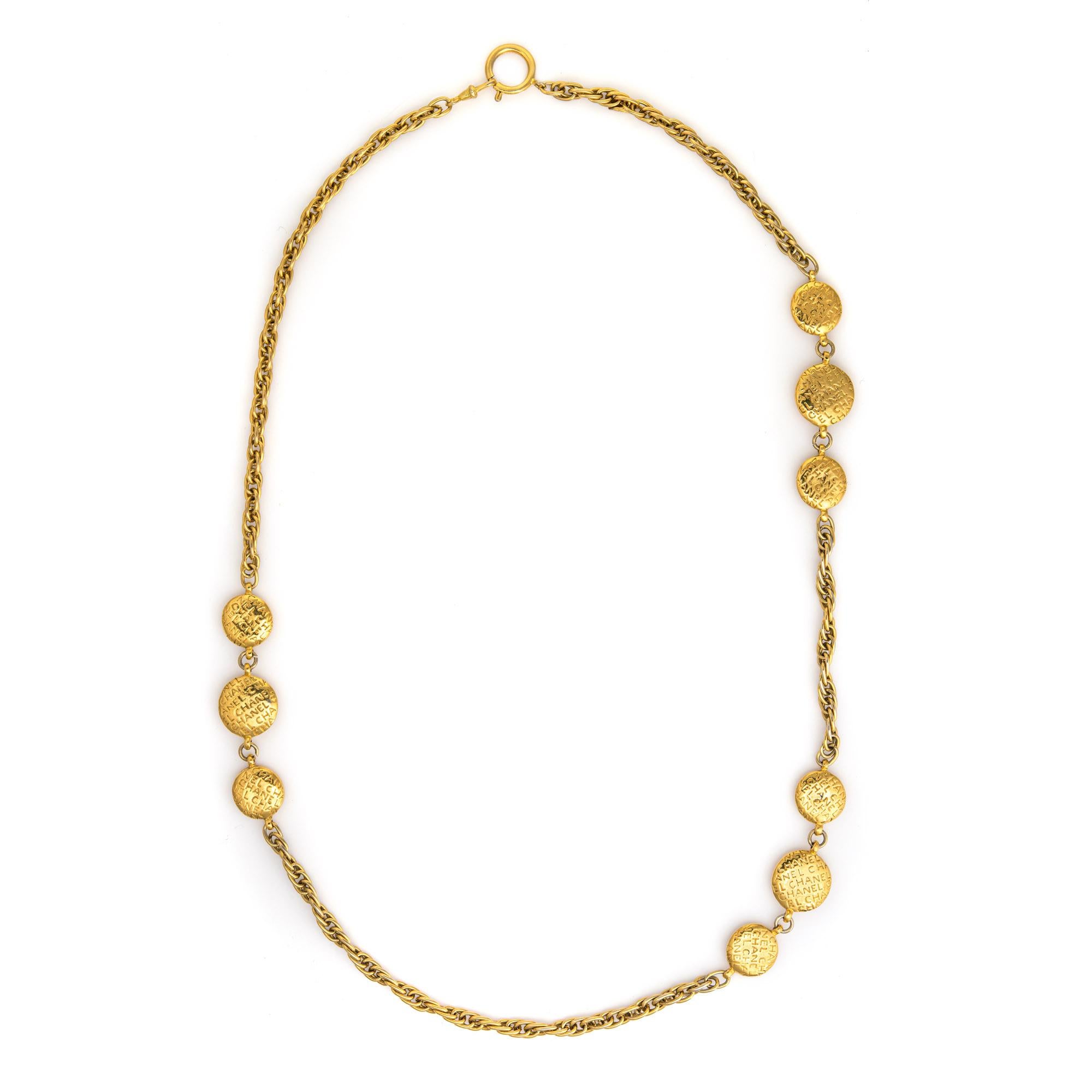 Vintage 70s Chanel medallion necklace crafted in yellow gold-tone (circa 1971-1980). 

The necklace features three medallion stations with repeating 'Chanel' scripts. The reverse side of the larger medallion features the silhouette of Coco Chanel.