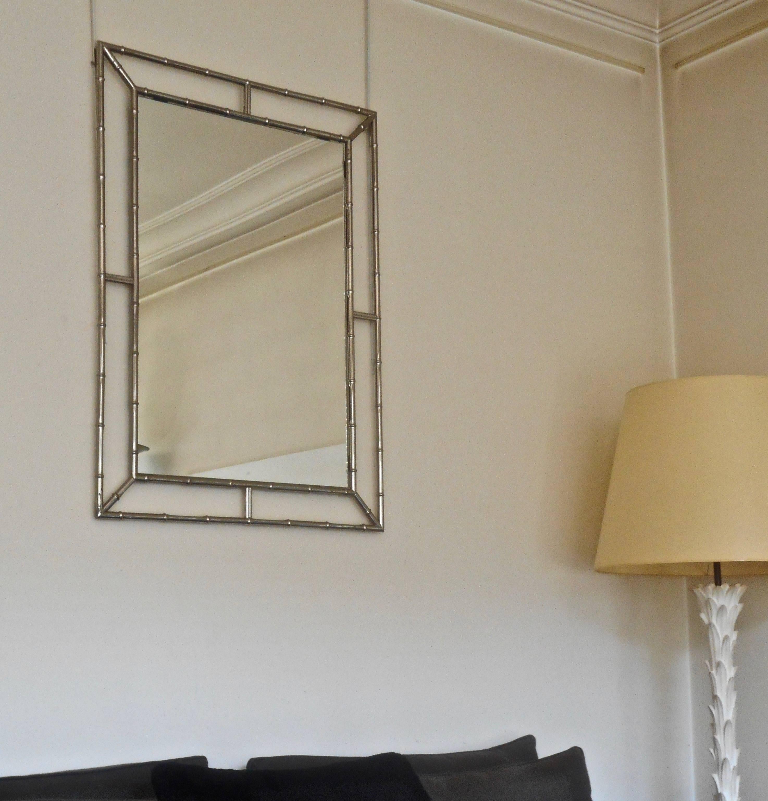 In the style of Maison Jansen, elegant faux bamboo wall mirror in silvered metal.
France, circa 1970.