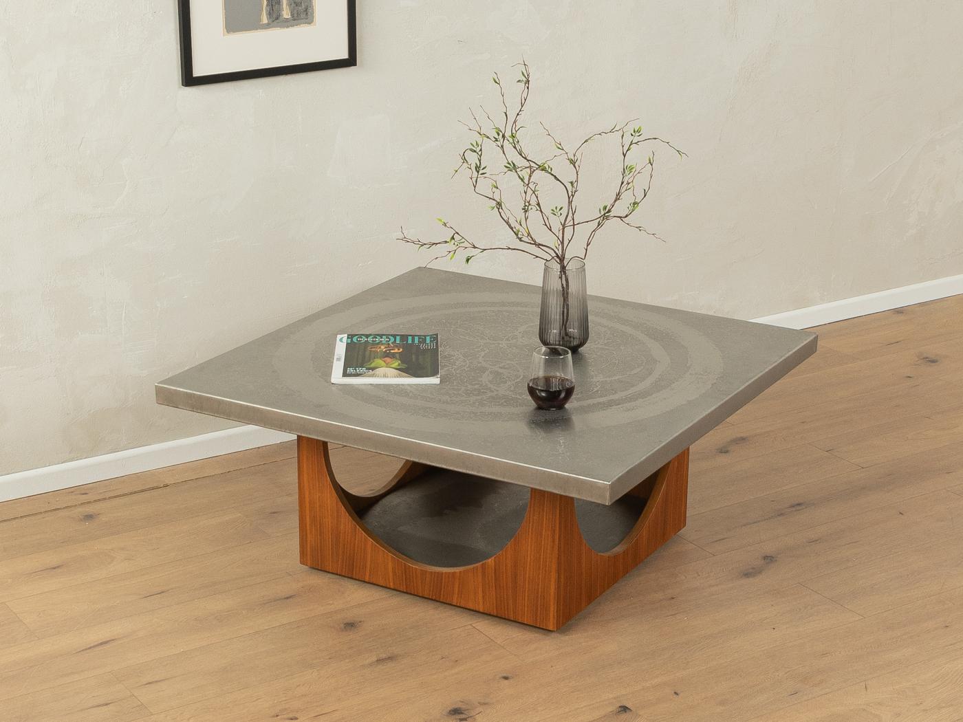 Table basse classique de Heinz Lilienthal datant des années 1970. Base en bois de haute qualité en placage de noyer avec roulettes en plastique et plateau décoratif recouvert d'une feuille d'acier inoxydable avec motif gravé...

Caractéristiques de