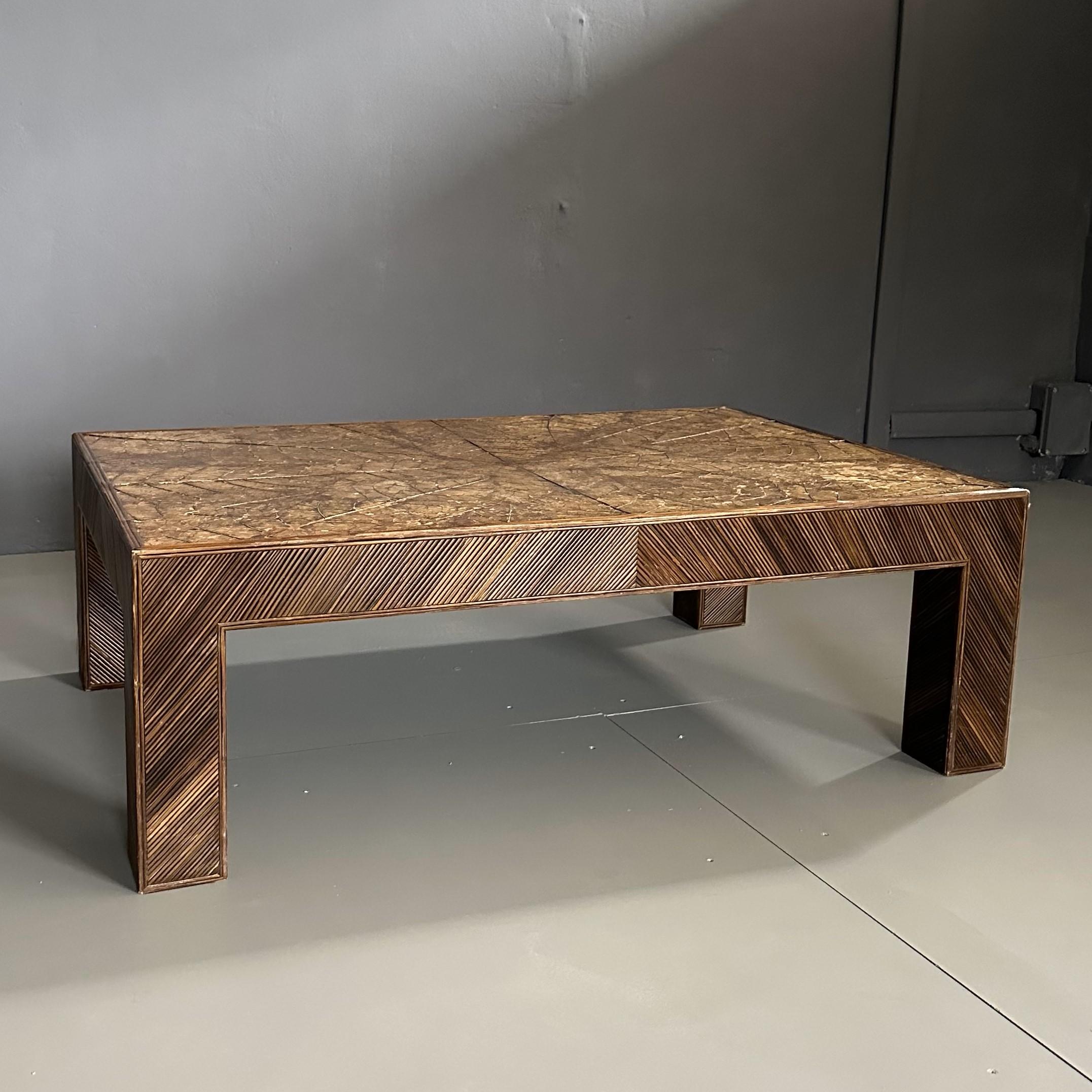 70s coffee table, in bamboo with tobacco leaf top by Arpex International.
The coffee table has beautiful bamboo finishes with a tobacco leaf on the top.
The rectangular-shaped coffee table along the profile has particular finishes