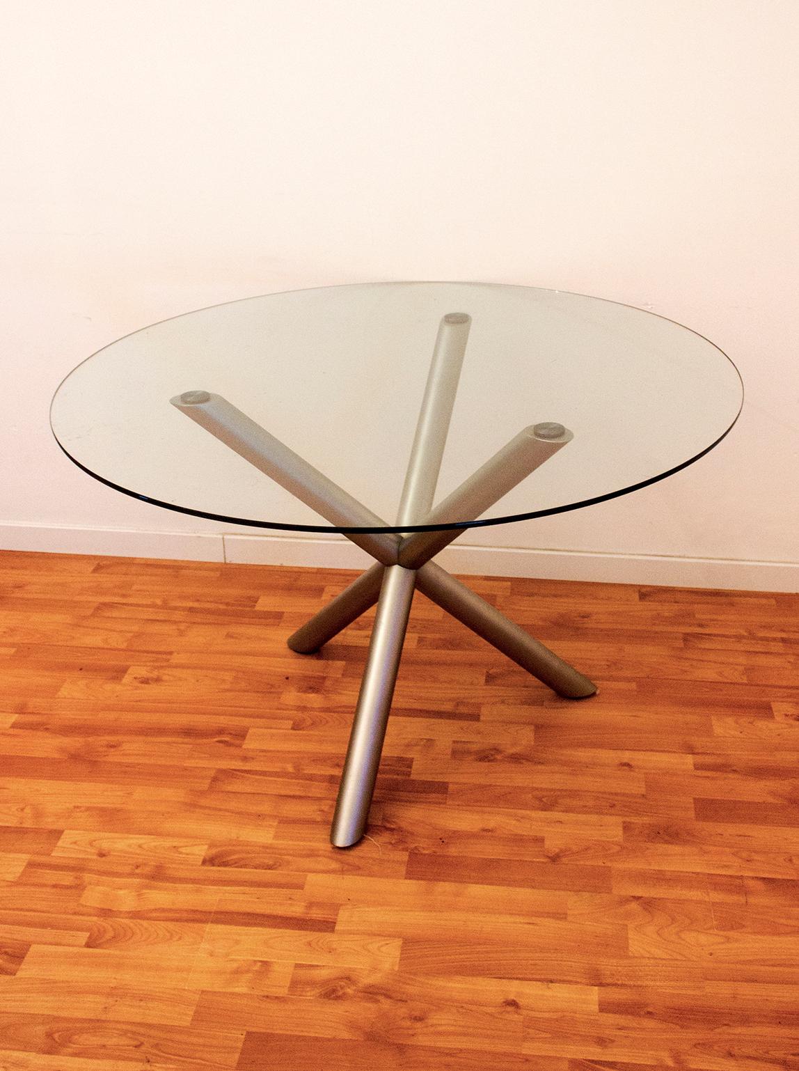 Introducing our round smoked glass dining table with a chrome tripod base, designed by Renato Zevi and manufactured by Roche Bobois in France during the Mid-Century period of design, from 1970 to 1979.

This dining table features a timeless and