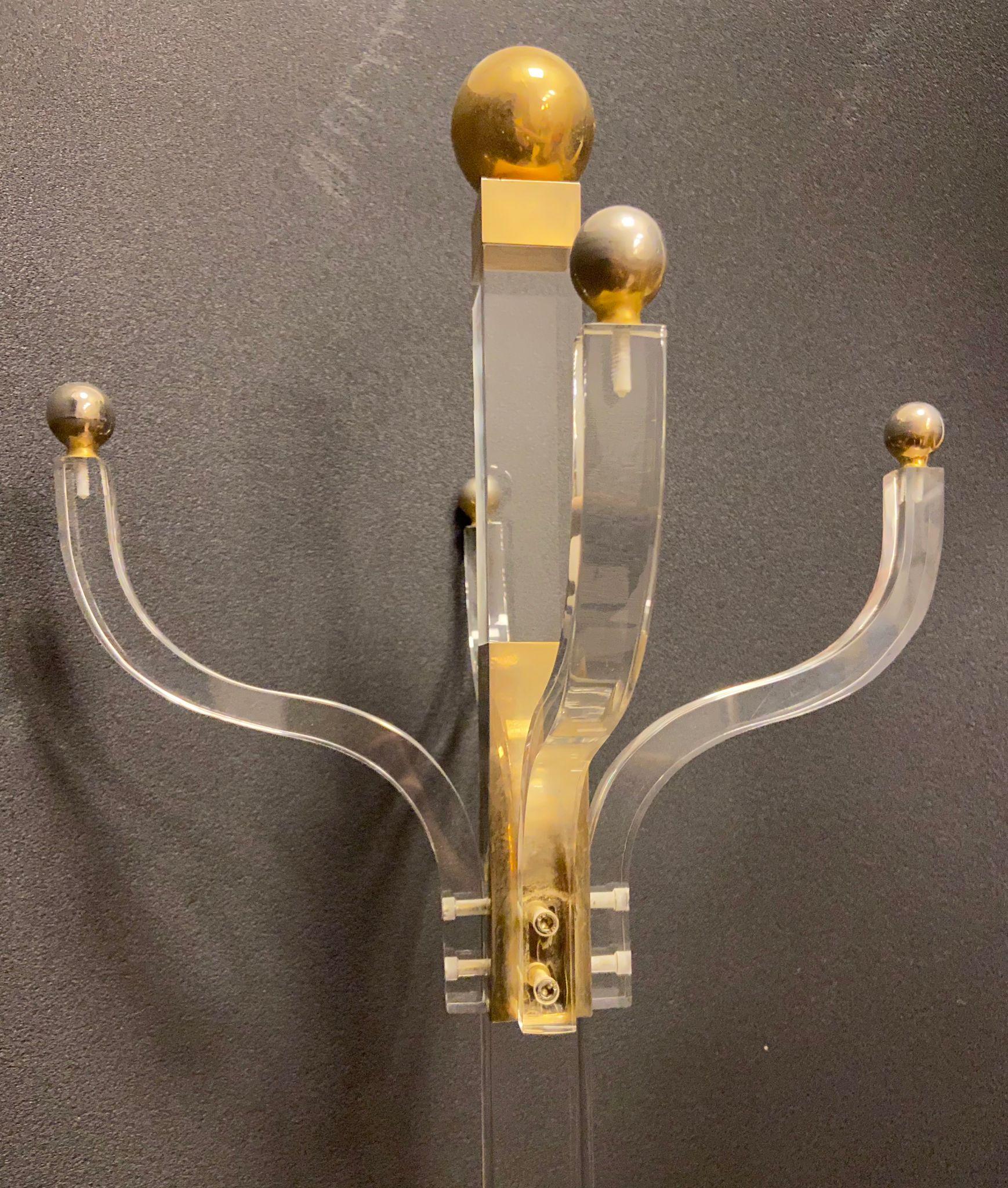 Bellissimo appendiabiti in stile anni '70, realizzato in metacrilato e con dettagli in ottone dorato. È composto da 4 appendini, tutti rifiniti con preziose sfere dorate, oltre a uno centrale, che danno un tocco eccezionale e bilanciano il pezzo nel