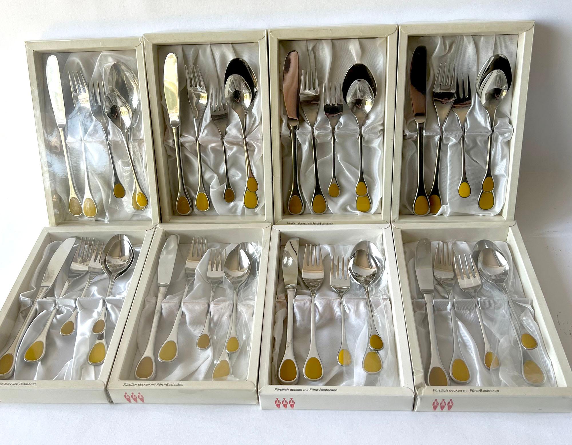 Large set of 8, five piece place settings by Furst Furosil made in Germany, circa 1970s. Made of bright stainless steel with yellow acrylic placed at the handle ends. Serveware pattern is 