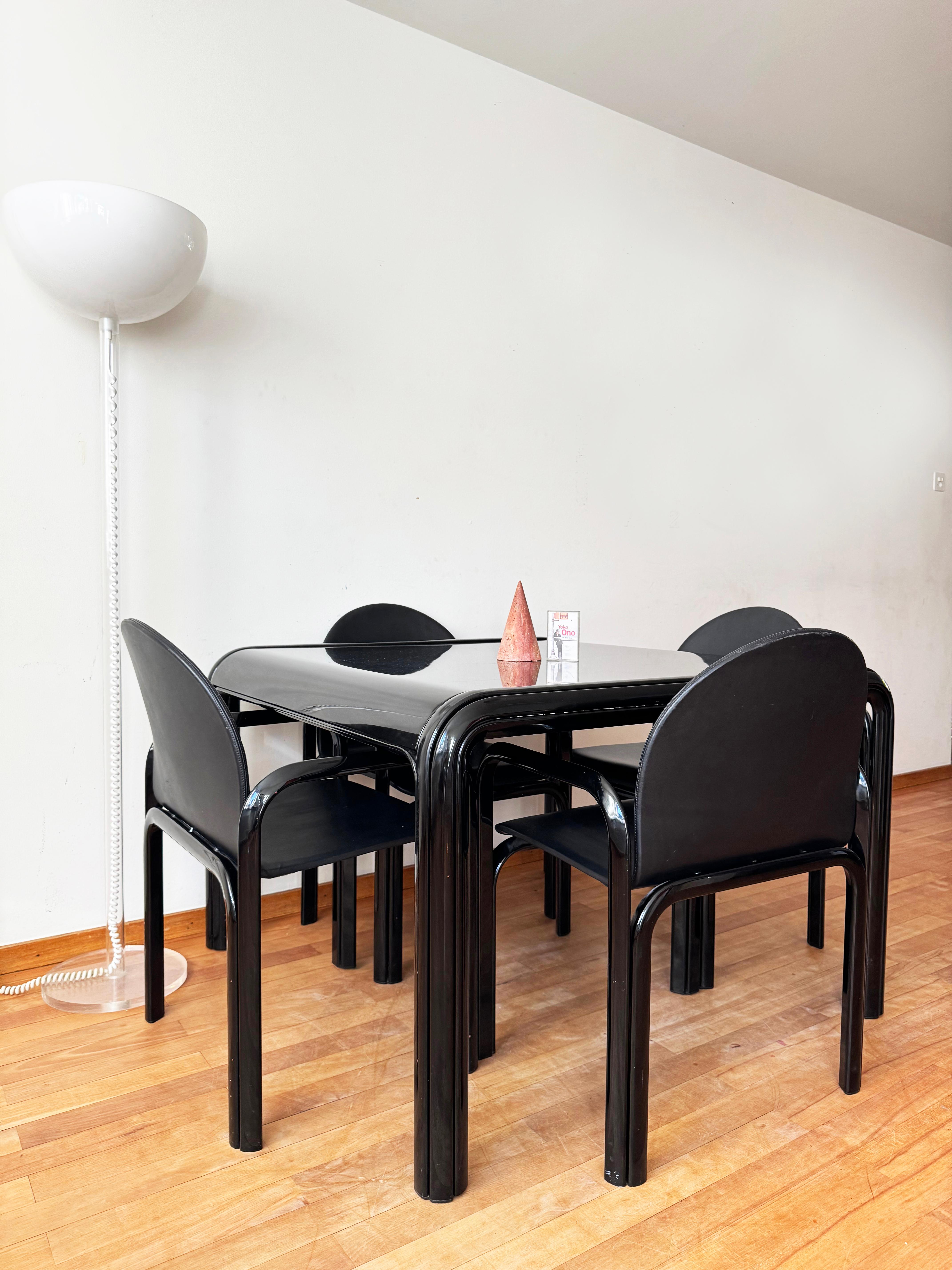 The listing includes an exceptionally rare complete dining set consisting of a black square table and four matching black leather armchairs designed in 1969 for Knoll International. The spacious table—referred to as “Model 54” within the Aulenti