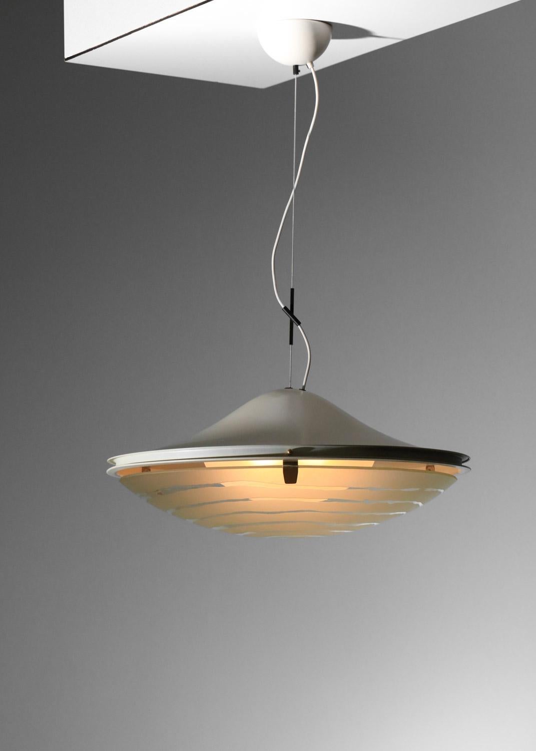 Hanging lamp from the 70s by Italian designer Gaetano Sciolari for Stilnovo. Structure in beige lacquered metal and brass. Curved glass diffuser decorated with a frosted pattern. Adjustable overall height. Beautiful vintage condition, with slight