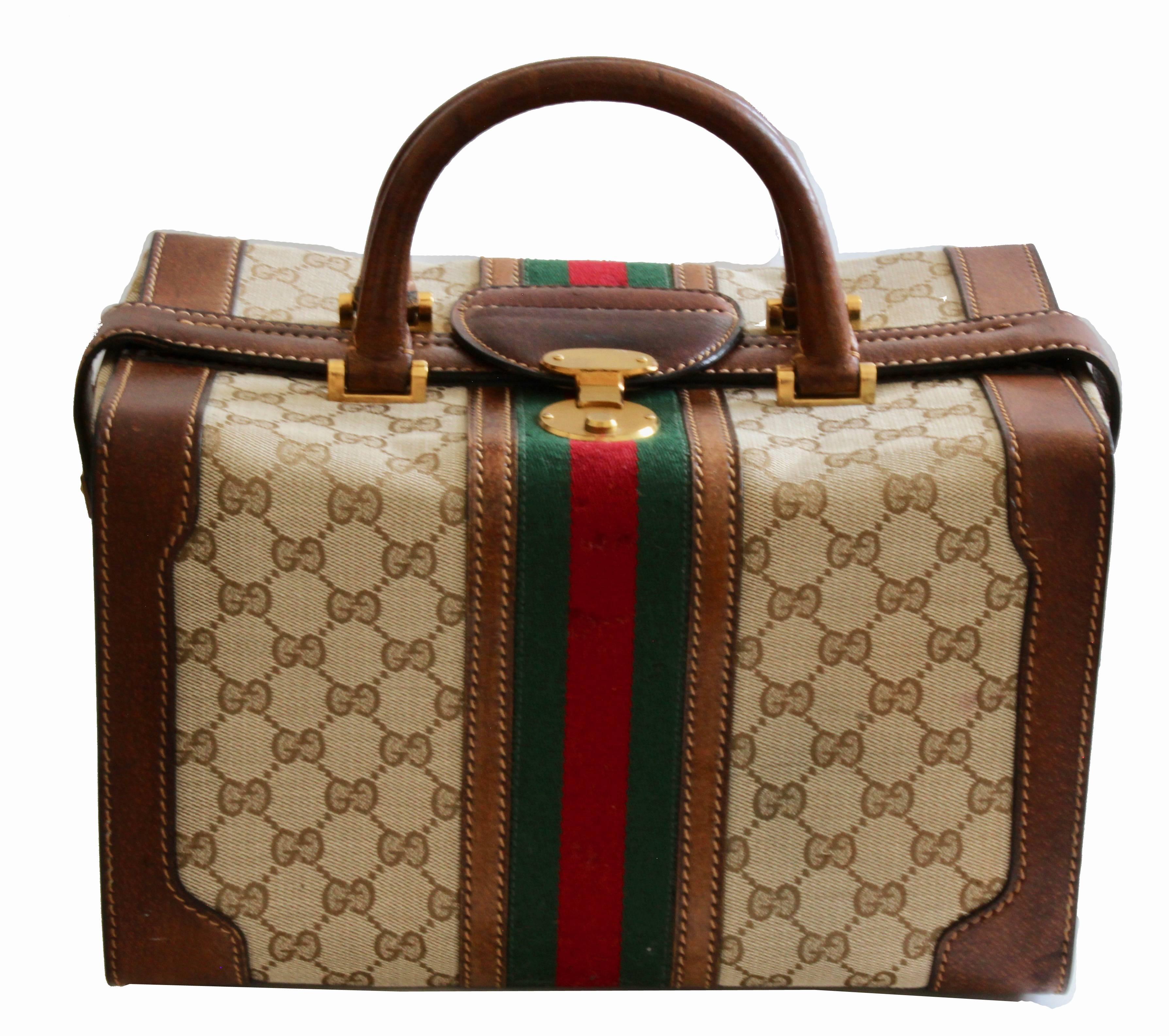 This fabulous train case was made by Gucci, most likely in the 1970s.  Made from their brown GG logo canvas with webbing, it opens doctor bag style with three latches.  Inside is fully lined with one zipper pocket and an adjustable bottle holder