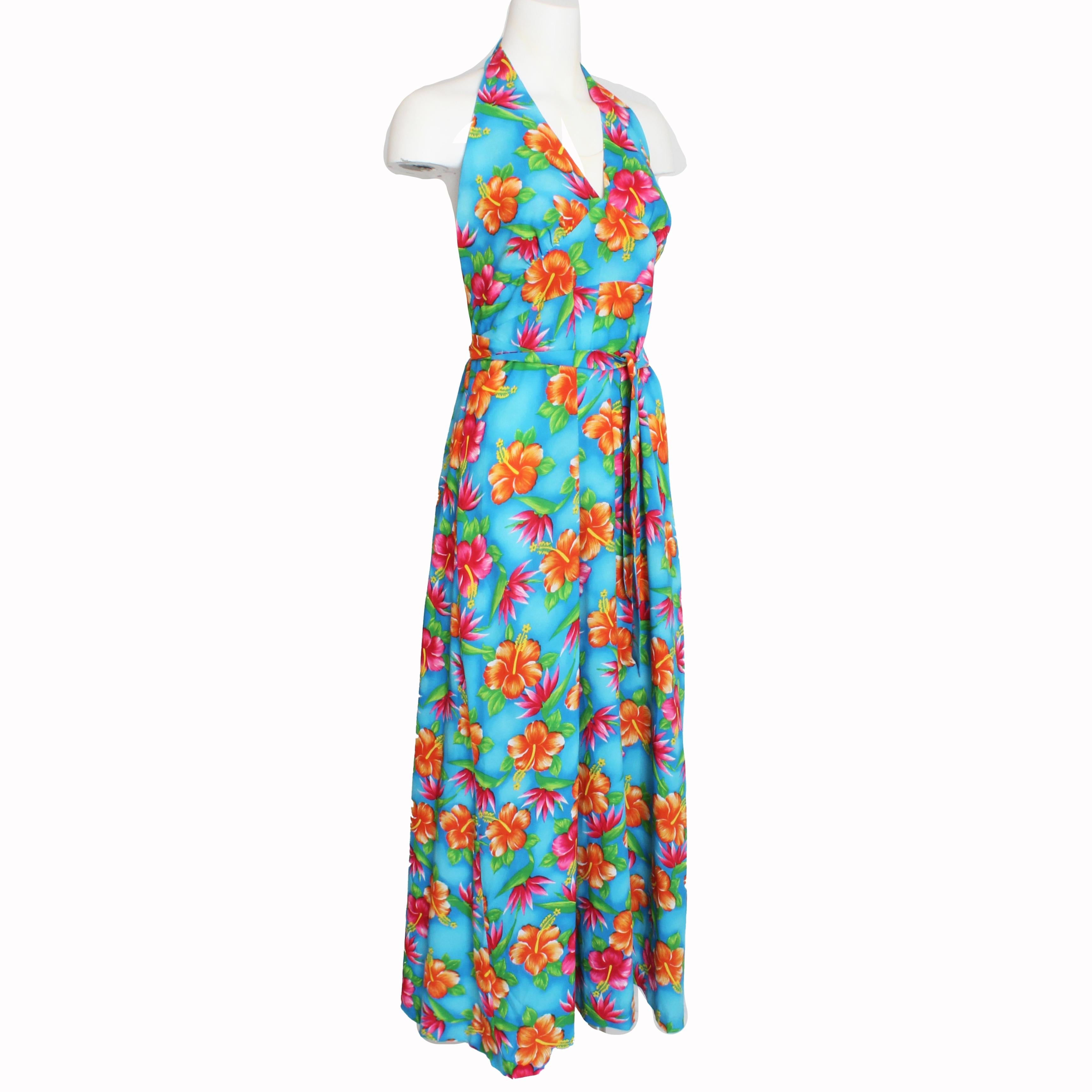 Este atrevido vestido halter con estampado hawaiano fue fabricado en los años 60 por POMARE, la empresa matriz de HILO HATTIE.  El estampado de este vestido es francamente vibrante y fabuloso, perfecto para llevarlo en tus vacaciones en la playa o