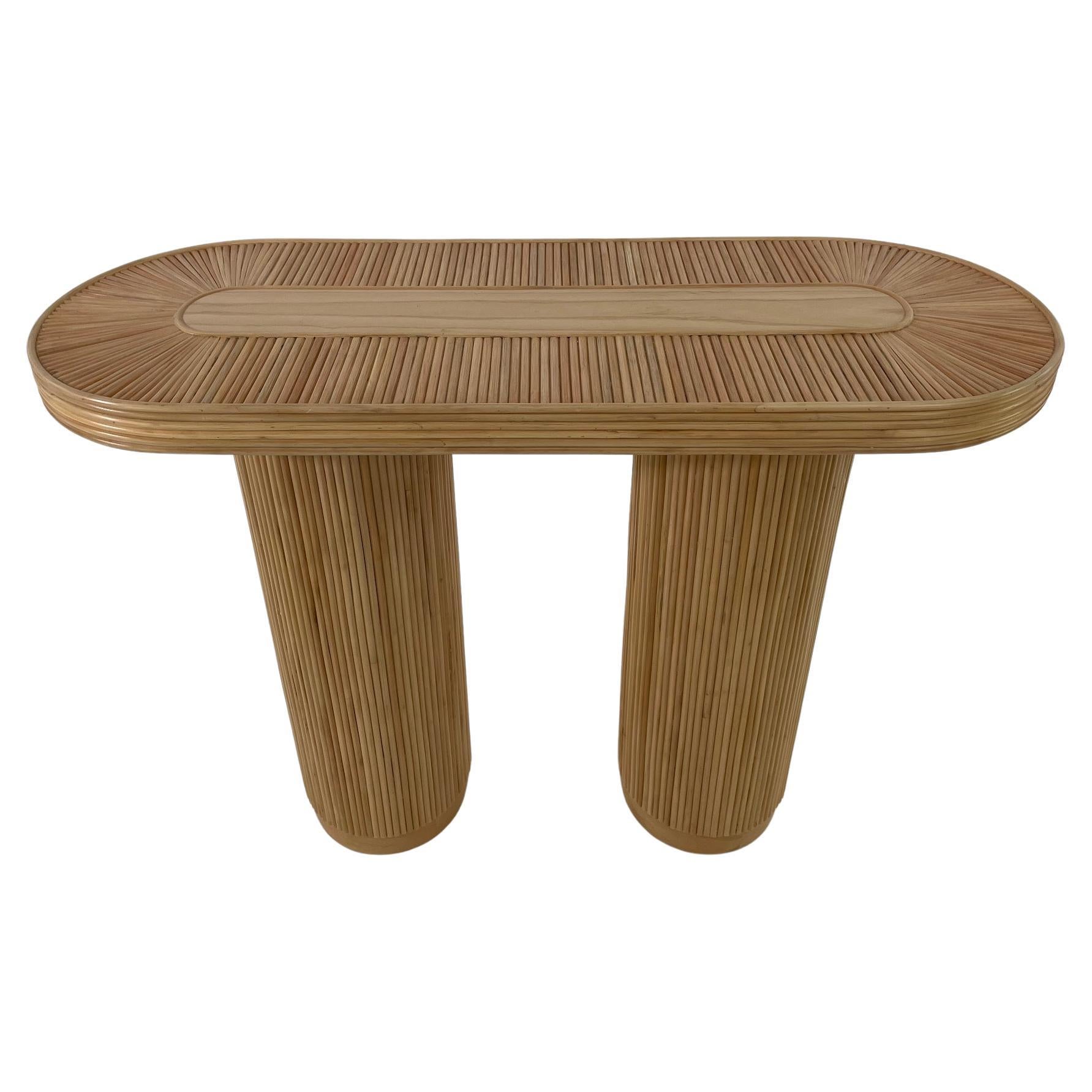 table console ronde et ovale en rotin tressé de style design italien des années 70, composée d'une structure en bois ornée d'une marqueterie de rotin tressé faite à la main, de deux pieds cylindriques (hauteur 72 cm / diamètre 24 cm) et d'un plateau